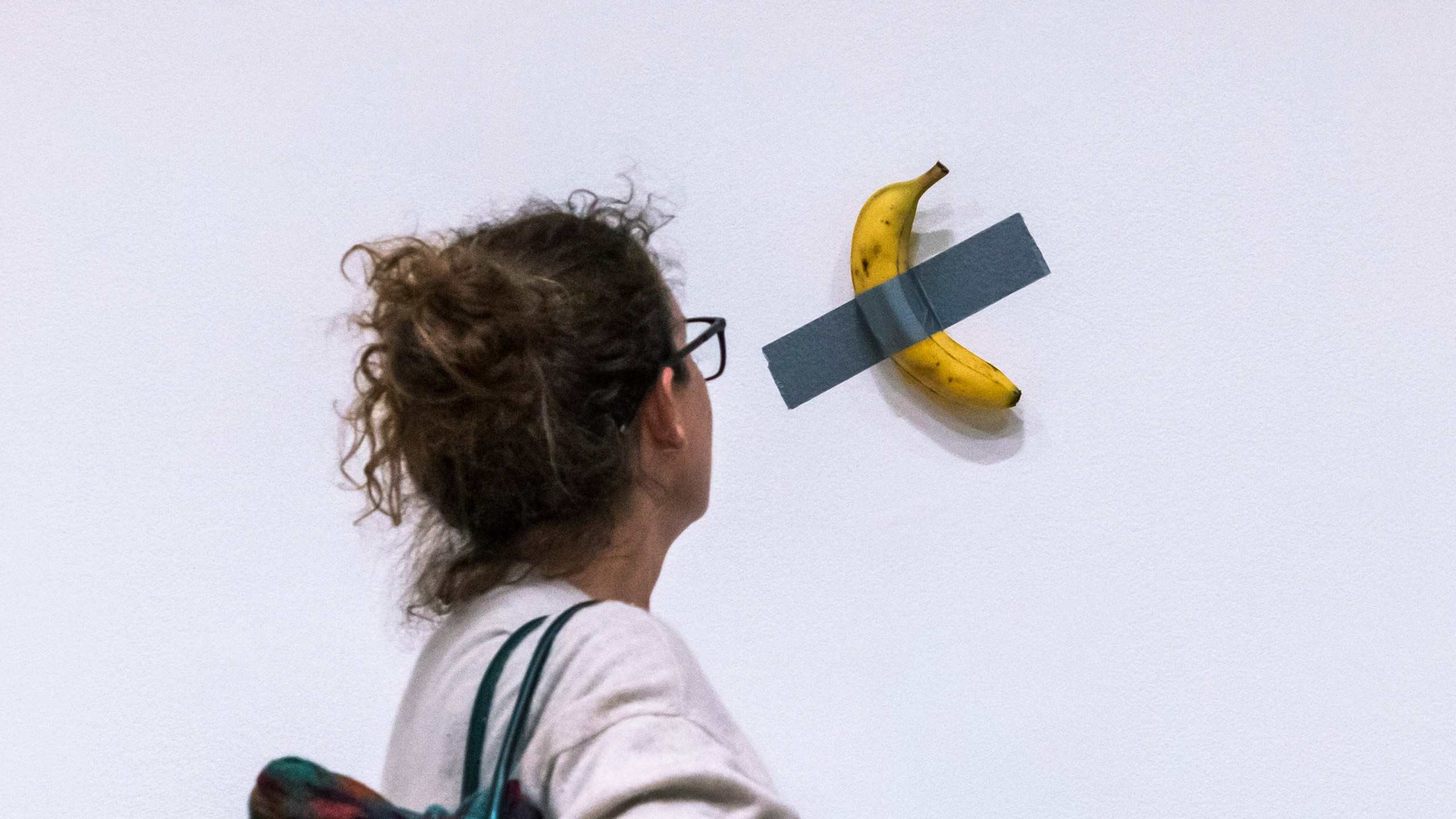 File - A woman looks at artist Maurizio Cattelan's piece of art "Comedian" during an auction preview at Sotheby's in New York, Monday, Nov. 11, 2024. (AP Photo/Eduardo Munoz Alvarez, File)