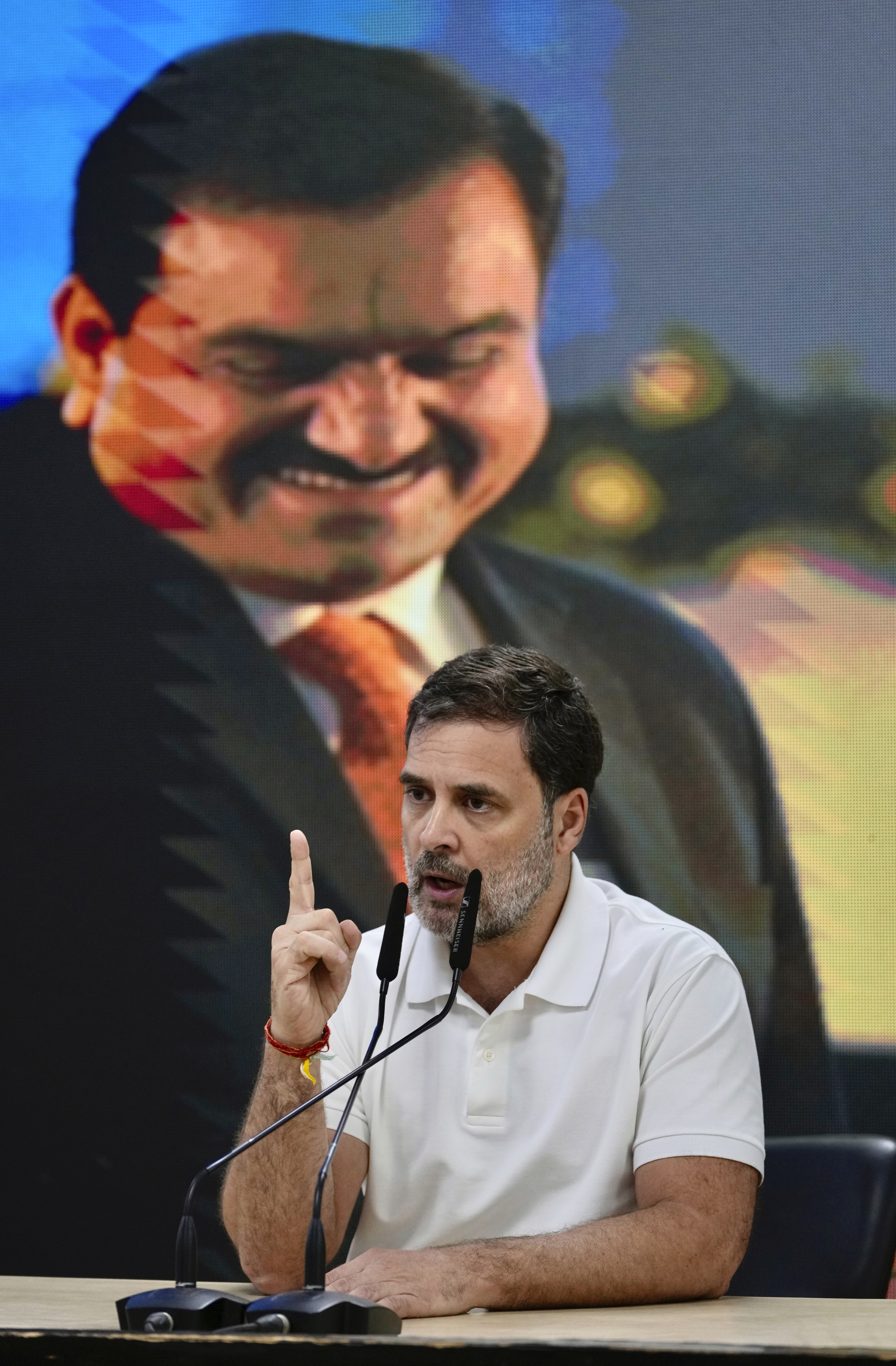 India's opposition Congress party leader Rahul Gandhi, addresses the media on Indian businessman Gautam Adani, after Adani was indicted by U.S. prosecutors on charges he duped investors in a massive solar energy project in India, in New Delhi, India, Thursday, Nov. 21, 2024. An image of Adani is behind. (AP Photo/Manish Swarup)