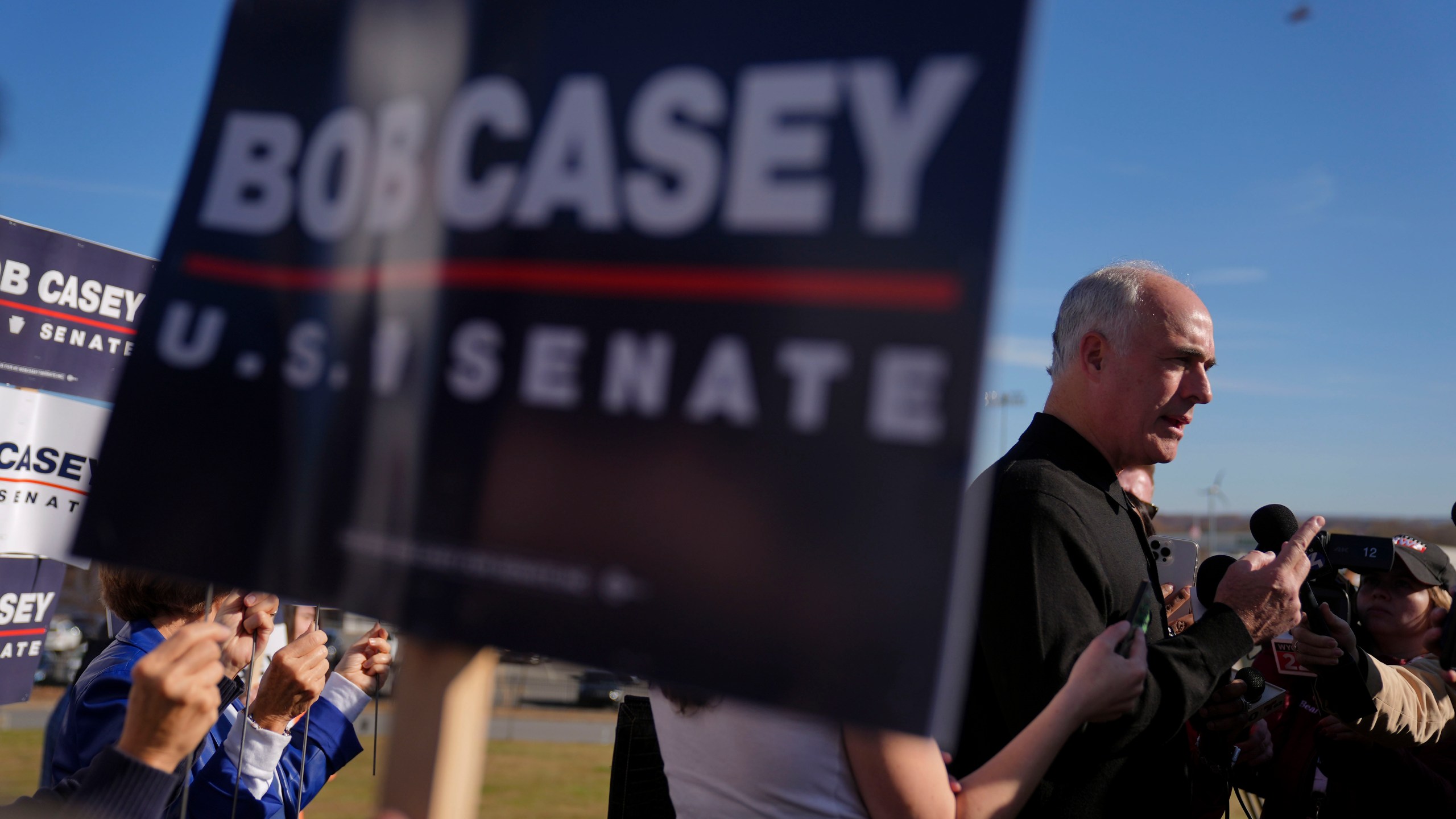 Sen. Bob Casey, D-Pa., left, stops to speak to members of the media before voting, Tuesday, Nov. 5, 2024, in Scranton, Pa. (AP Photo/Matt Rourke)