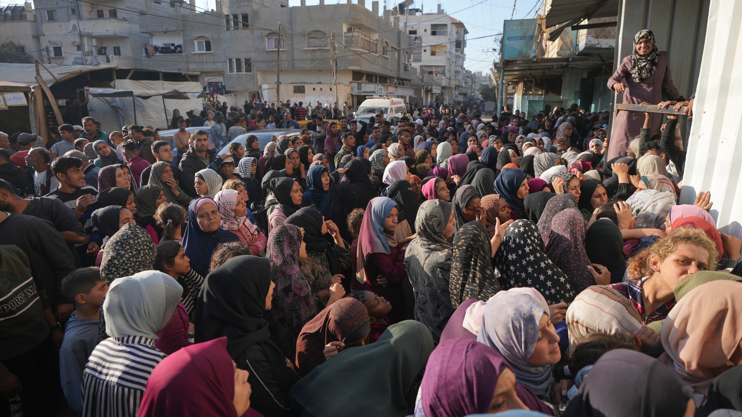 A crowd gathers in front of a bakery to get a share of bread in Deir al-Balah, Gaza Strip, Thursday Nov. 21, 2024. Some bakeries in the Gaza Strip have reopened Thursday morning after shuttering for several days due to a flour shortage and lack of food aid.(AP Photo/Abdel Kareem Hana)