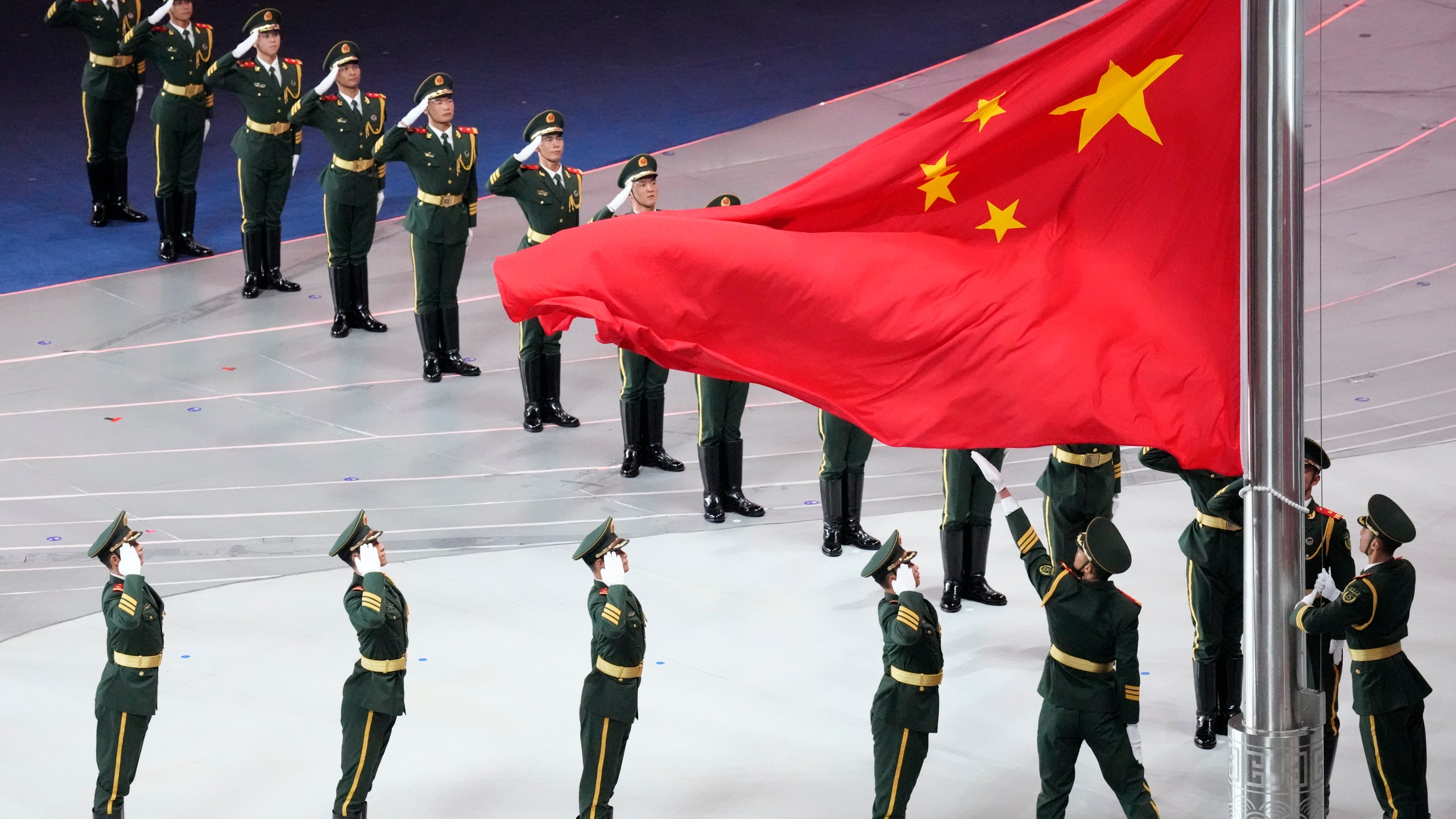 FILE - Military salute at the Chinese flag during the opening ceremony of the 19th Asian Games in Hangzhou, China, on Sept. 23, 2023. (AP Photo/Eugene Hoshiko, File)