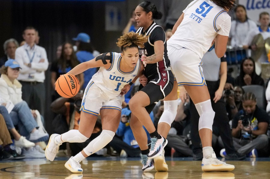 UCLA guard Kiki Rice (1) dribbles against South Carolina guard Te-Hina Paopao (0) during the first half of an NCAA college basketball game, Sunday, Nov. 24, 2024, in Los Angeles. (AP Photo/Eric Thayer)