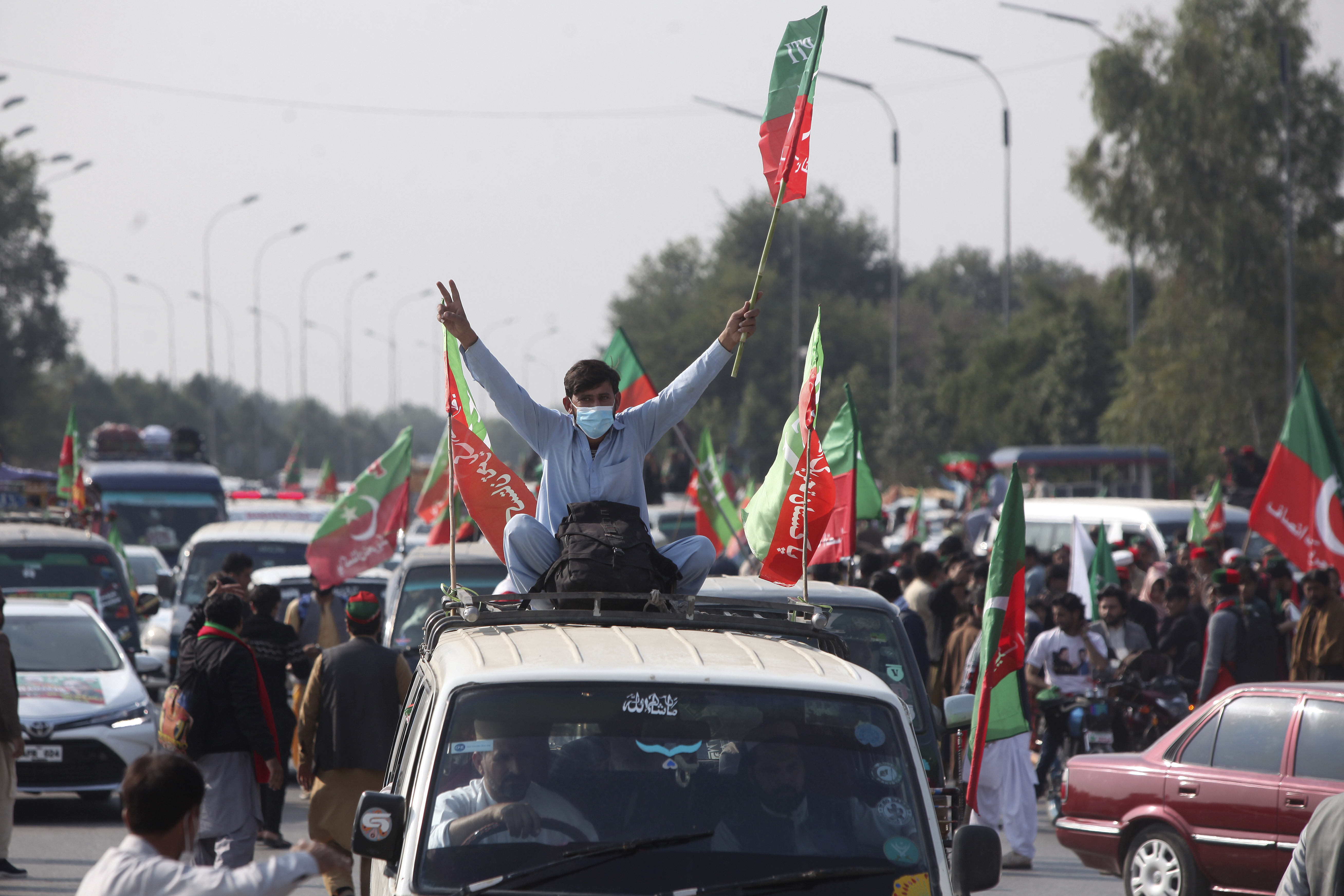 Supporters of imprisoned former premier Imran Khan's Pakistan Tehreek-e-Insaf party, board into vehicles as they starting a rally for Islamabad to demand Khan's release, in Peshawar, Pakistan, Sunday, Nov. 24, 2024. (AP Photo/Muhammad Sajjad)