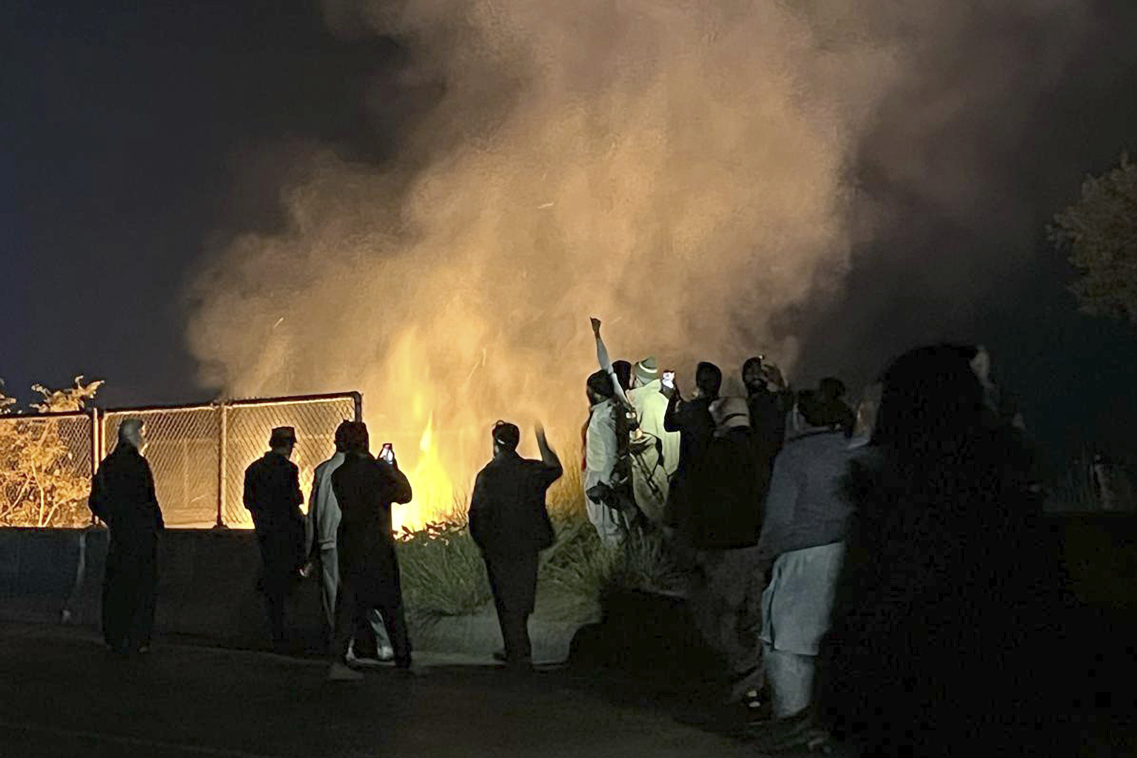 Supporters of imprisoned former premier Imran Khan's Pakistan Tehreek-e-Insaf party, burn bushes to reduce the impact of tear gas shells fired by police officers to disperse them during a rally demanding Khan's release, at a motorway in Ghazi in Attock district, Pakistan, Sunday, Nov. 24, 2024. (AP Photo/Maaz Awan)