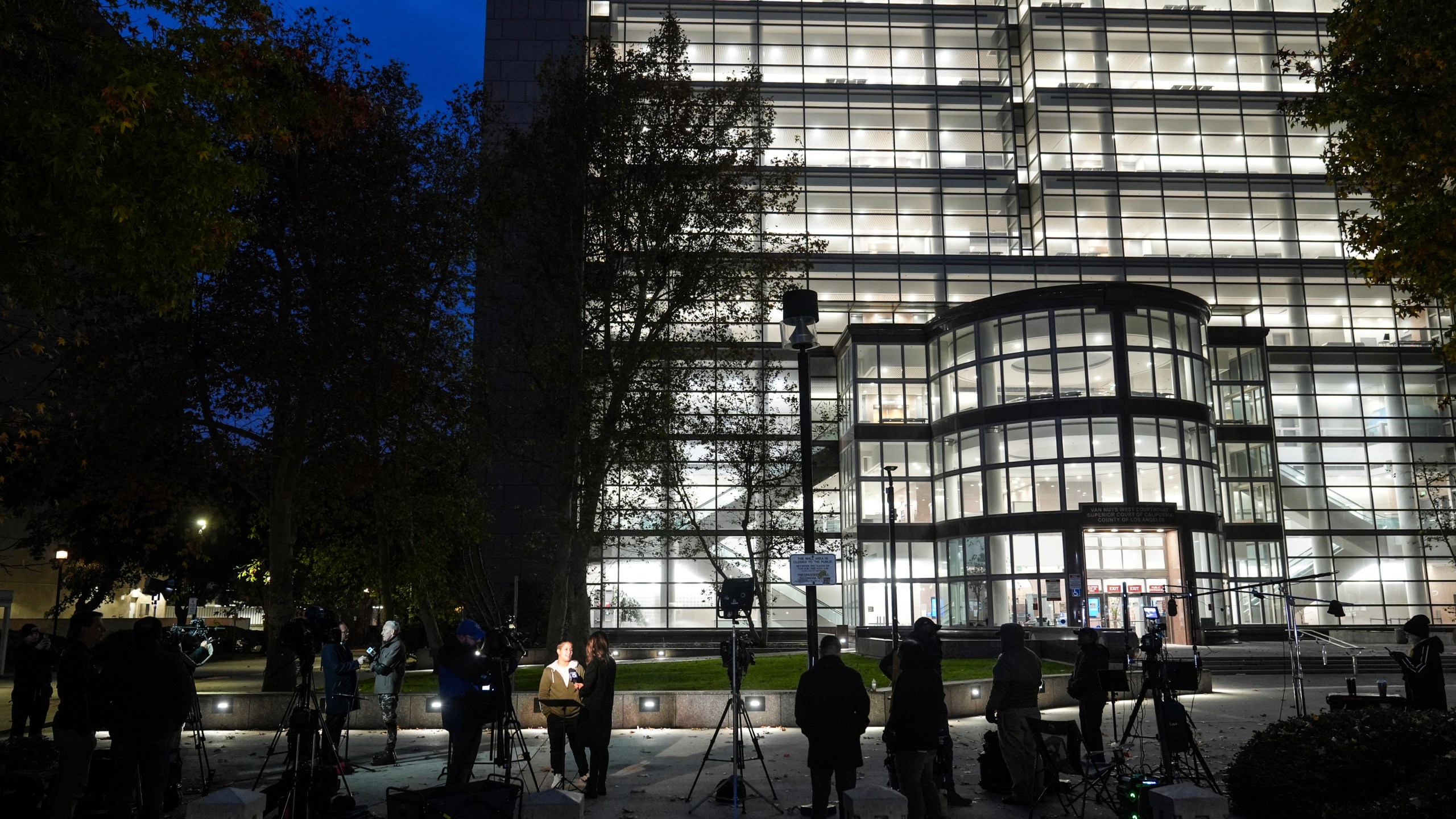 Media members gather outside the Van Nuys Courthouse West in Los Angeles, Monday, Nov. 25, 2024, where a hearing is scheduled in the case of Lyle and Erik Menendez, who are serving life sentences without the possibility of parole for the shotgun murders of their parents in their Beverly Hills home more than 30 years ago. (AP Photo/Jae C. Hong)