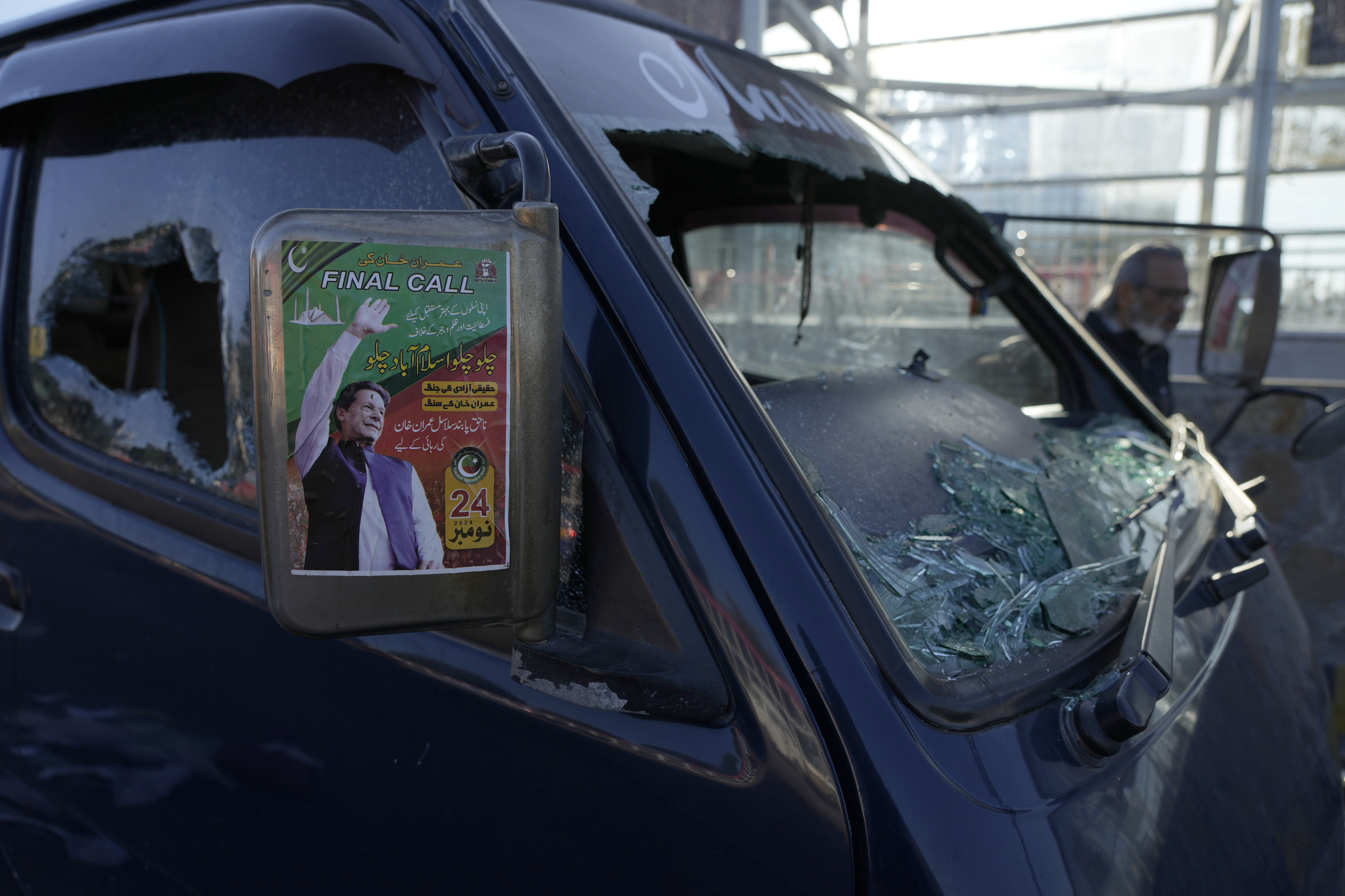 A poster of imprisoned former premier Imran Khan is displayed on a damaged vehicle left behind by supporters of Khan's Pakistan Tehreek-e-Insaf party after clashes with security forces the night before, in Islamabad, Pakistan, Wednesday, Nov. 27, 2024. (AP Photo/Anjum Naveed)