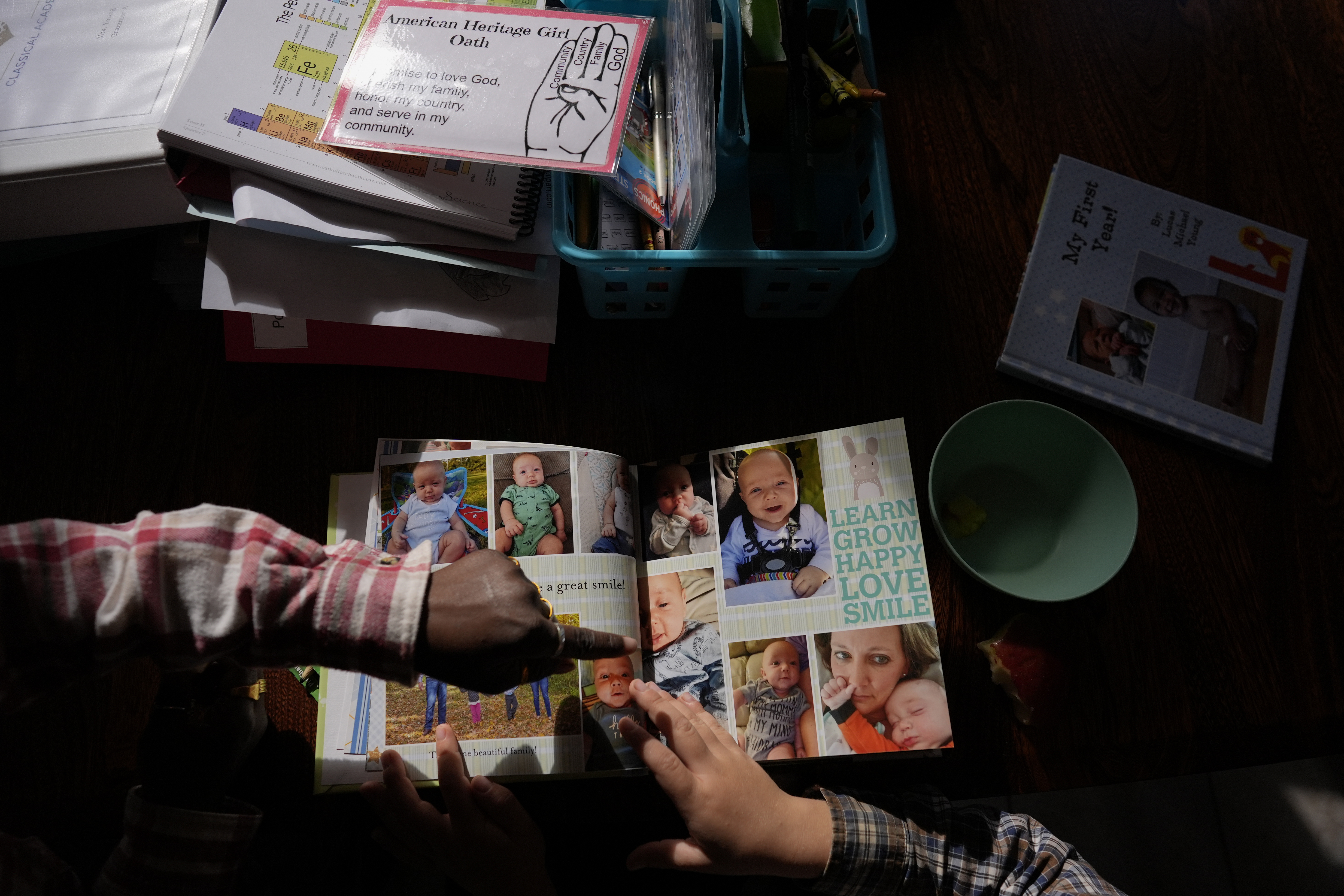 Isaac Young, 5, right, and his big sister Gianna Young, 7, look at his one-year baby book during a homeschool break in the dining room of their Sunbury, Ohio, home on Tuesday, Nov. 12, 2024. (AP Photo/Carolyn Kaster)