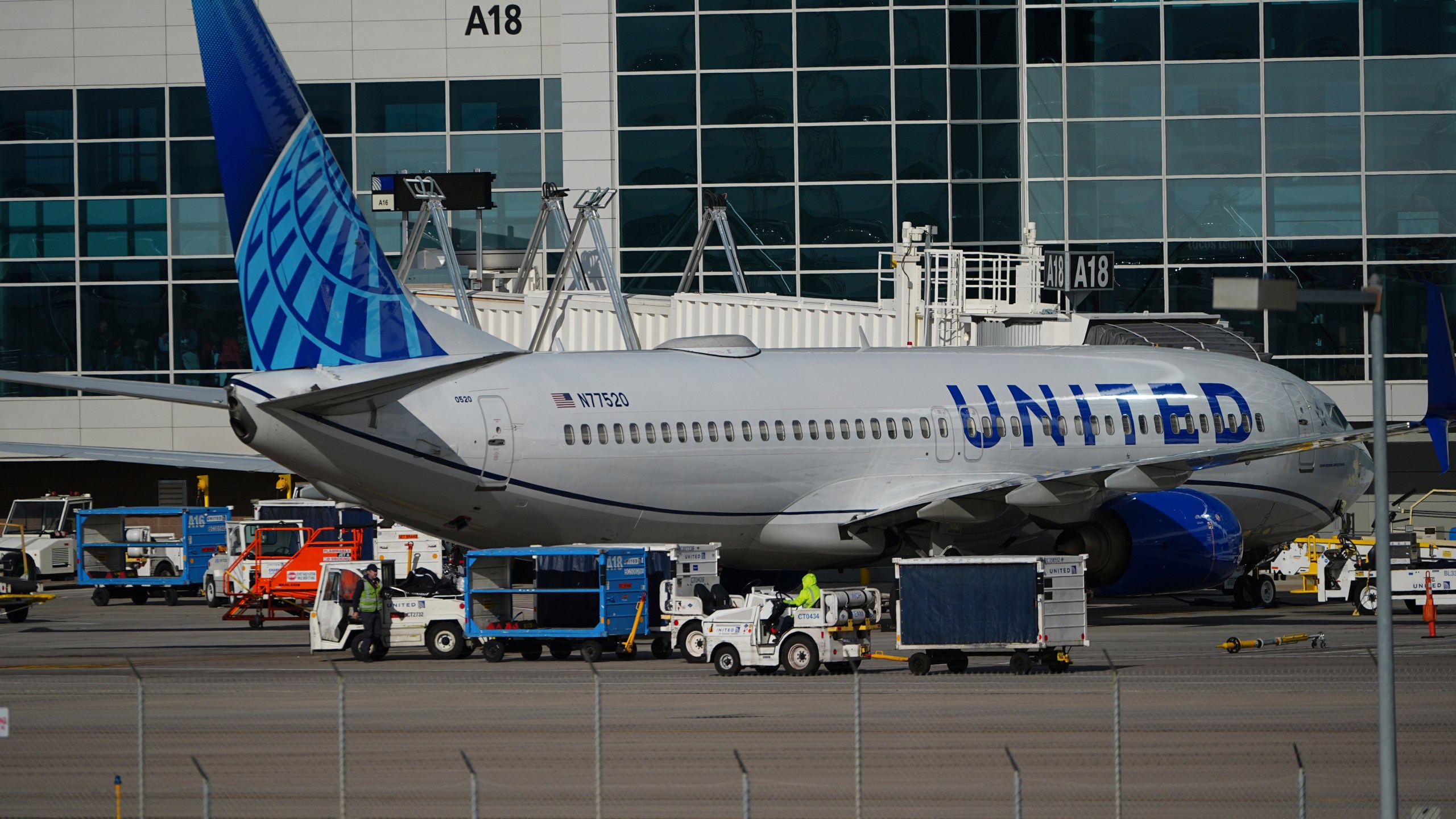 Workers prepare a United Airlines jetliner for departure from a gate on the A concourse at Denver International Airport Tuesday, Nov. 26, 2024, in Denver. (AP Photo/David Zalubowski)