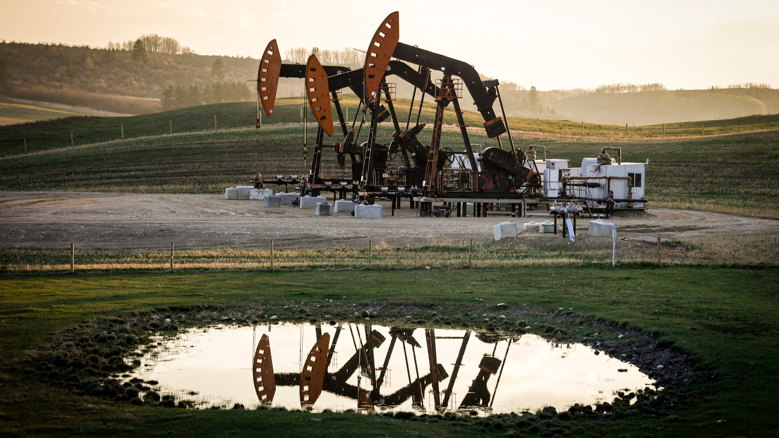 FILE - Pumpjacks draw out oil and gas from well heads as wildfire smoke hangs in the air near Calgary, Alberta, Sunday, May 12, 2024. (Jeff McIntosh/The Canadian Press via AP, File)