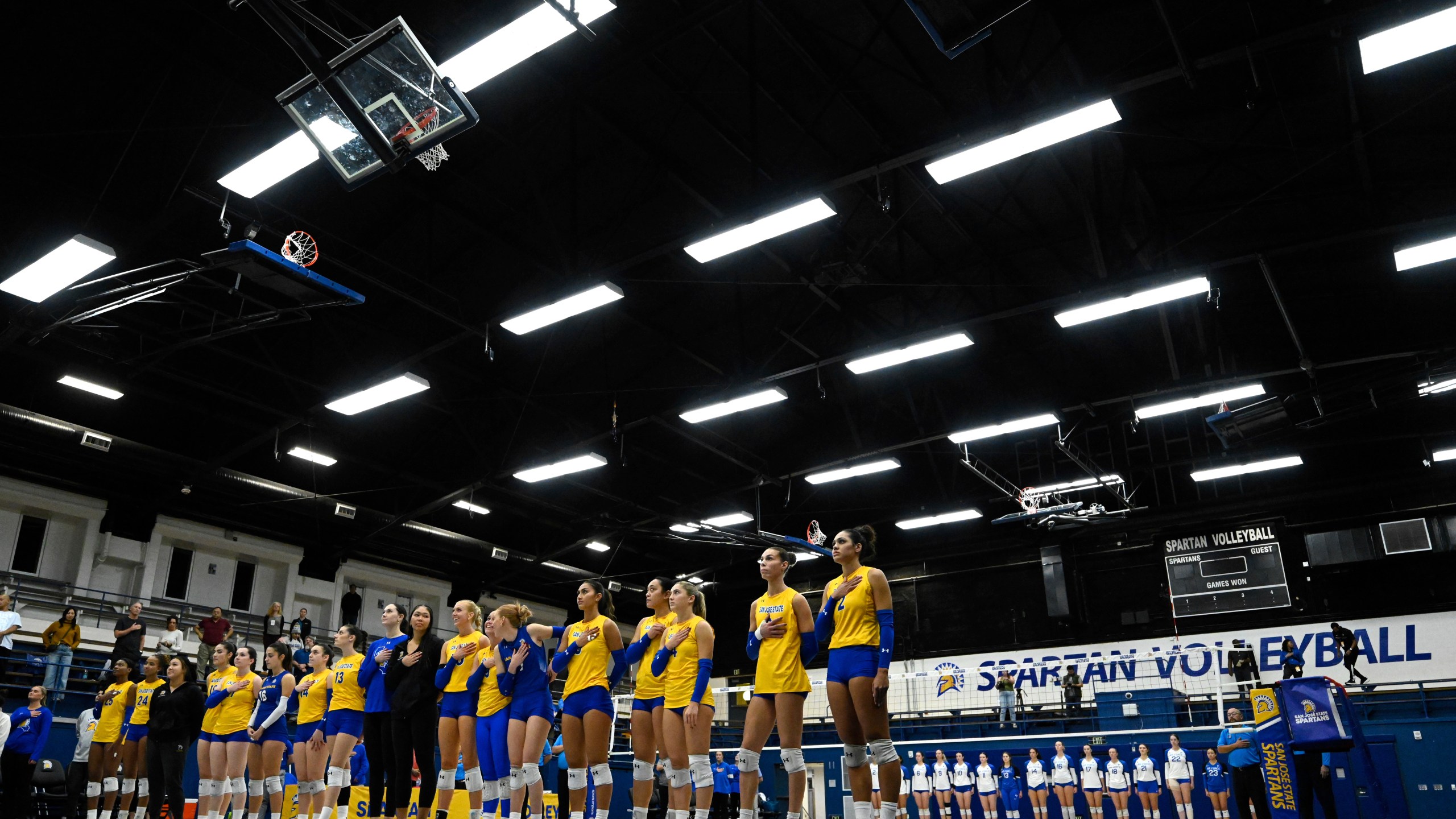 The San Jose State Spartans and Air Force Falcons stand for the National Anthem before an NCAA college volleyball match Thursday, Oct. 31, 2024, in San Jose, Calif. (AP Photo/Eakin Howard)