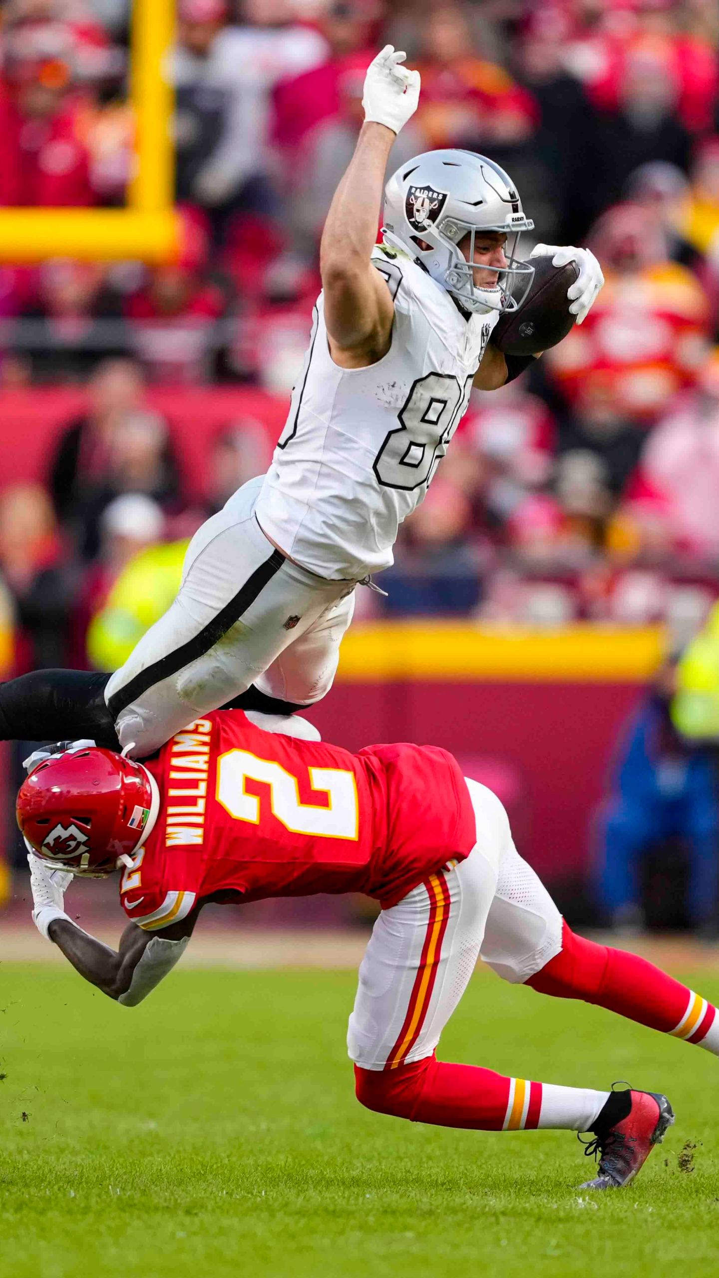 Las Vegas Raiders tight end Brock Bowers (89) tries to leap over Kansas City Chiefs cornerback Joshua Williams (2) during the first half of an NFL football game in Kansas City, Mo., Friday, Nov. 29, 2024. (AP Photo/Ed Zurga)