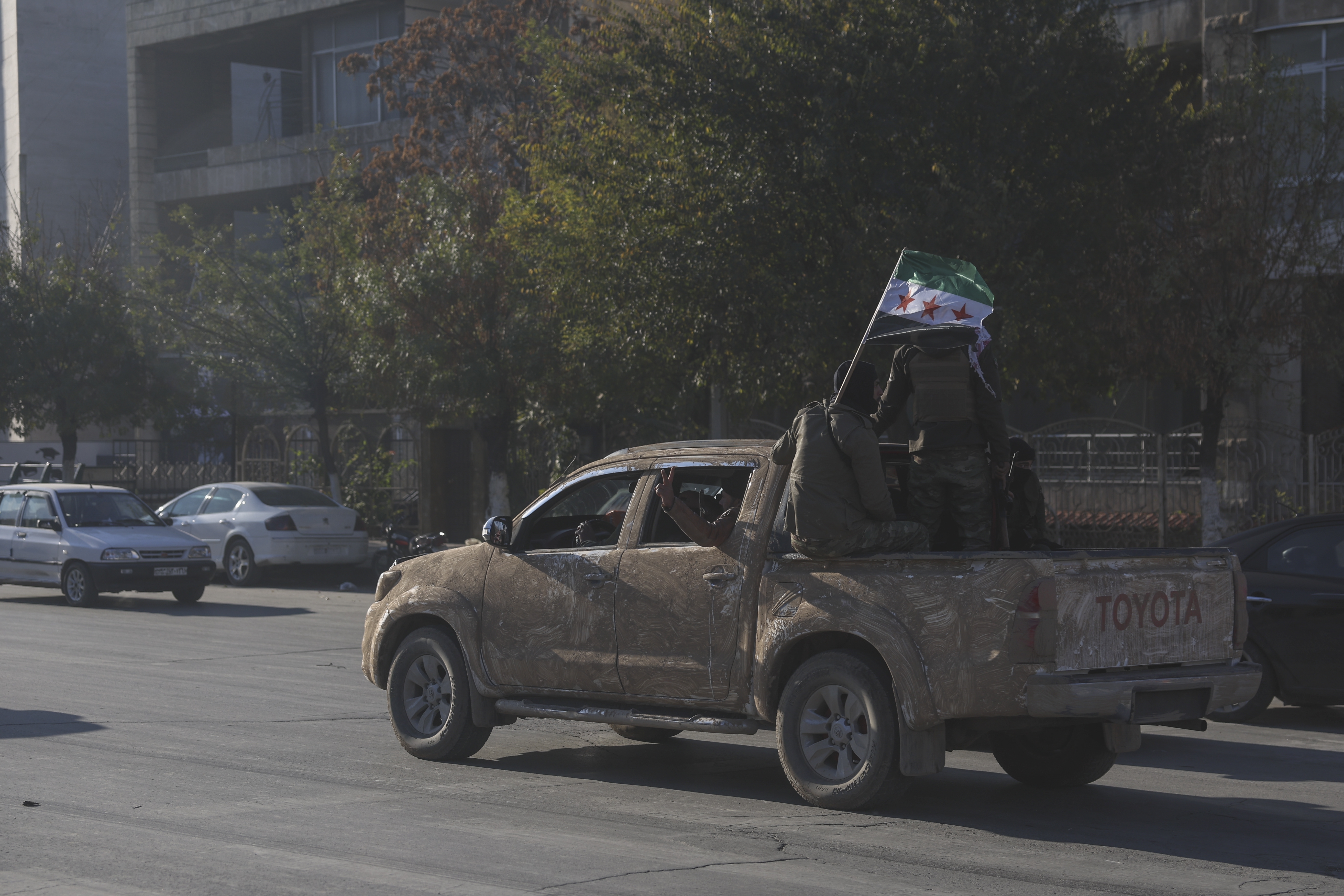 Opposition fighters ride along the streets of Aleppo, Syria, Saturday Nov. 30, 2024. (AP Photo/Ghaith Alsayed)