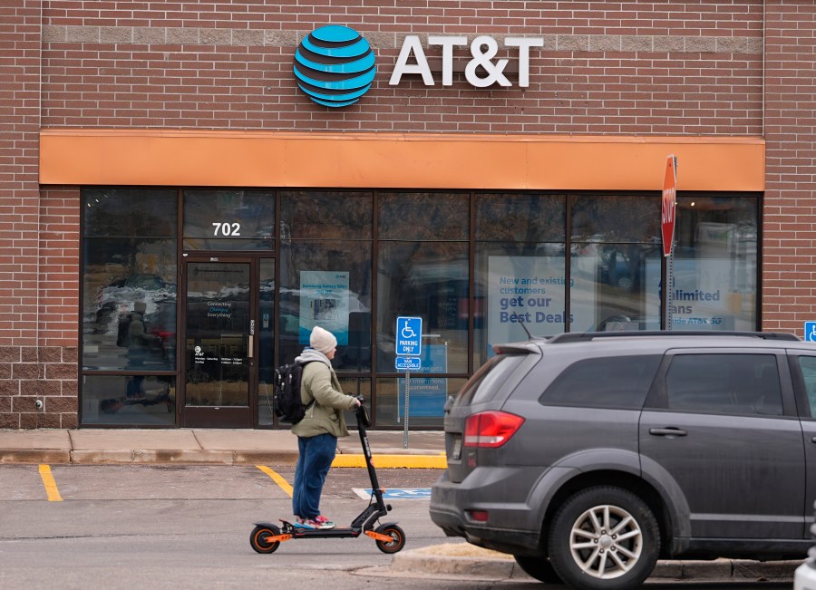 FILE - The company logo hangs over the door to a AT&T telephone store, Feb. 22, 2024, in Denver. (AP Photo/David Zalubowski, file)