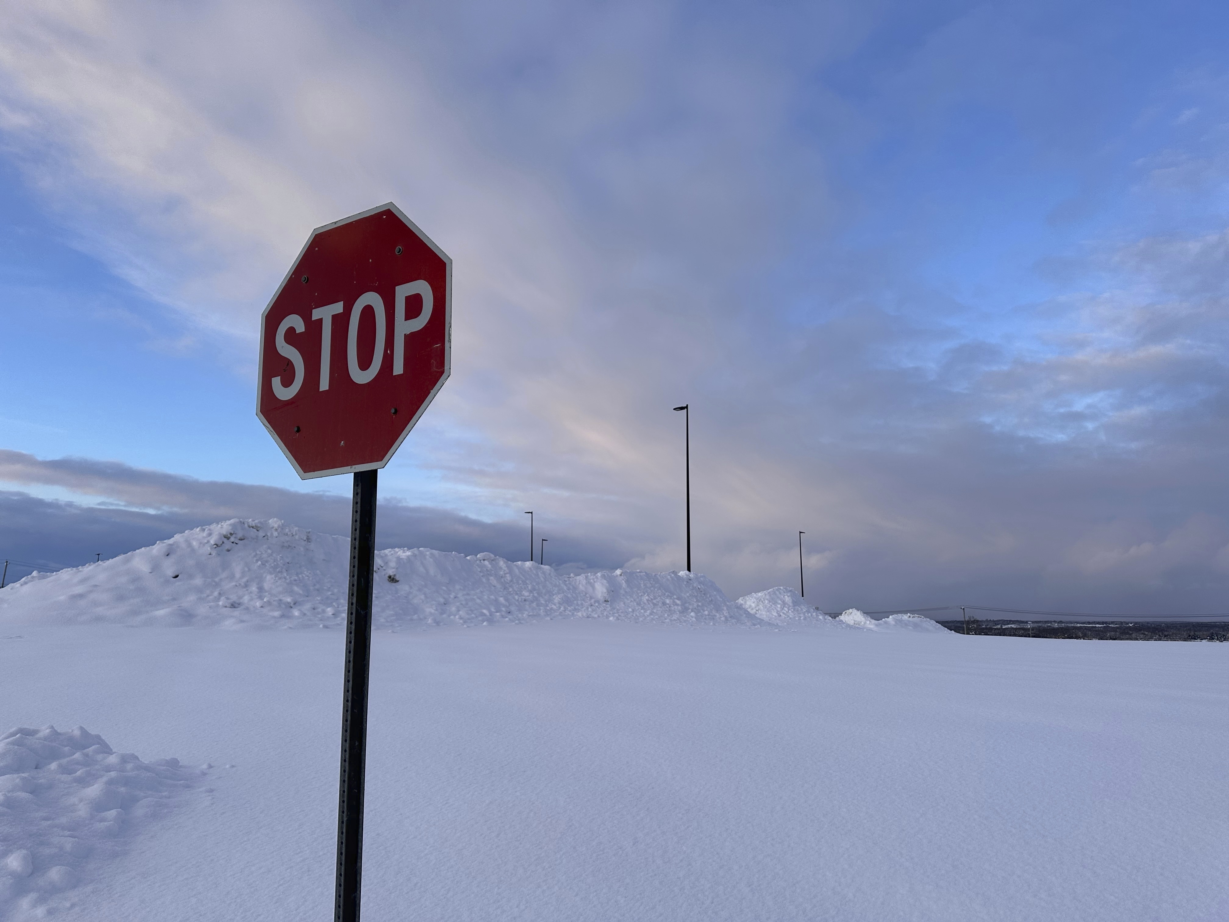 Snow is piled at a parking lot in Lowville, N.Y., on Tuesday, Dec. 3, 2024. (AP Photo/Cara Anna)