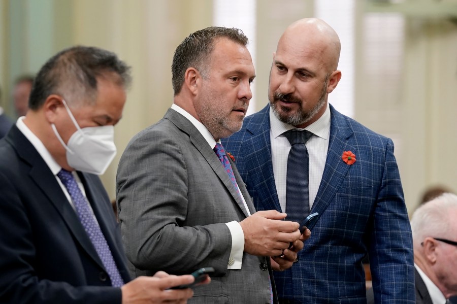 FILE -Central Valley Assembly members, Democrat Adam Gray, of Merced, center, and Republican Heath Flora of Ripon, right, confer during the Assembly session at the Capitol in Sacramento, Calif., May 27, 2022. (AP Photo/Rich Pedroncelli, File)