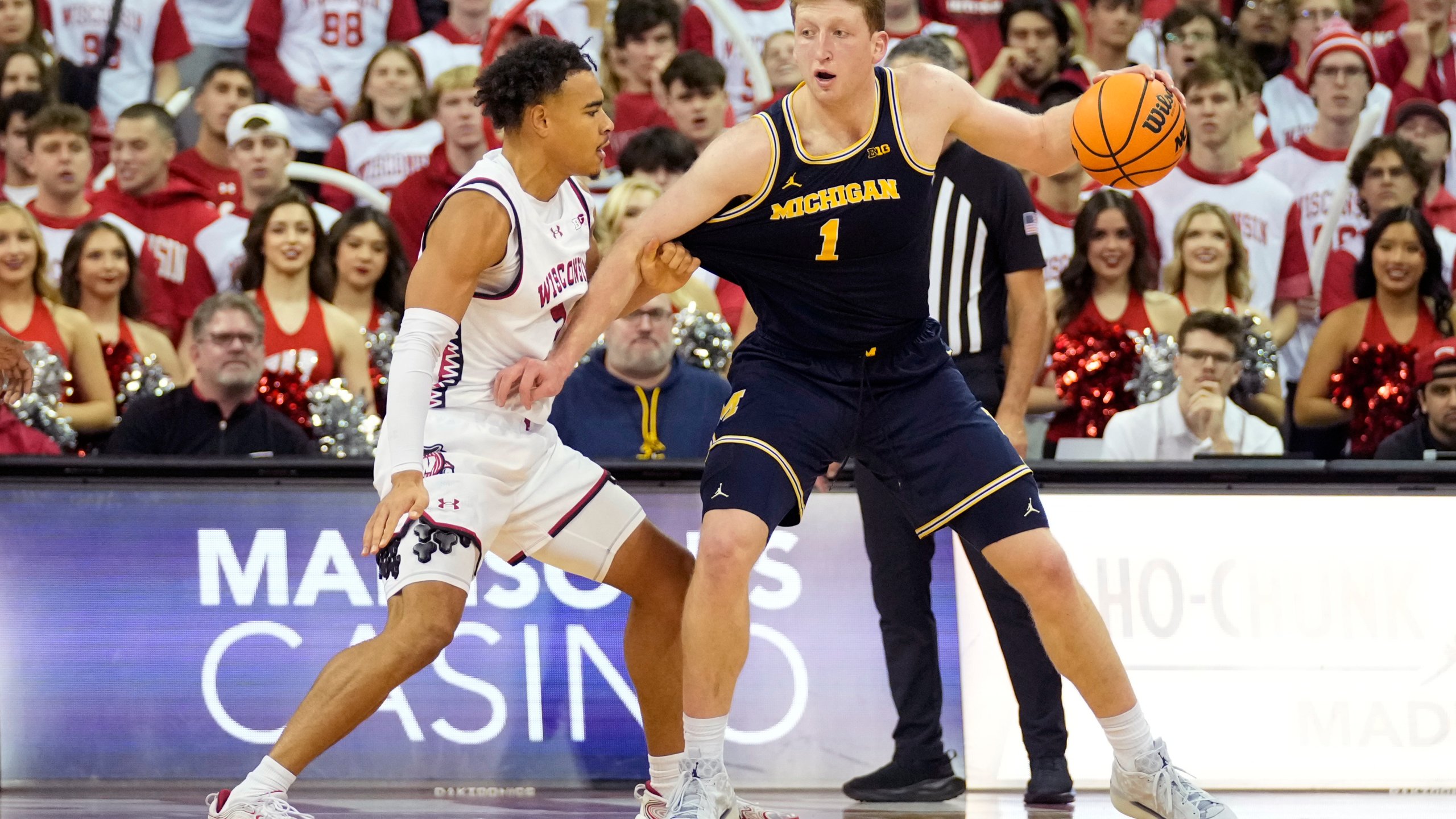 Michigan center Danny Wolf (1) dribbles the ball against Wisconsin guard John Tonje (9) during the second half of an NCAA college basketball game Tuesday, Dec. 3, 2024, in Madison, Wis. Michigan won 67-64. (AP Photo/Kayla Wolf)