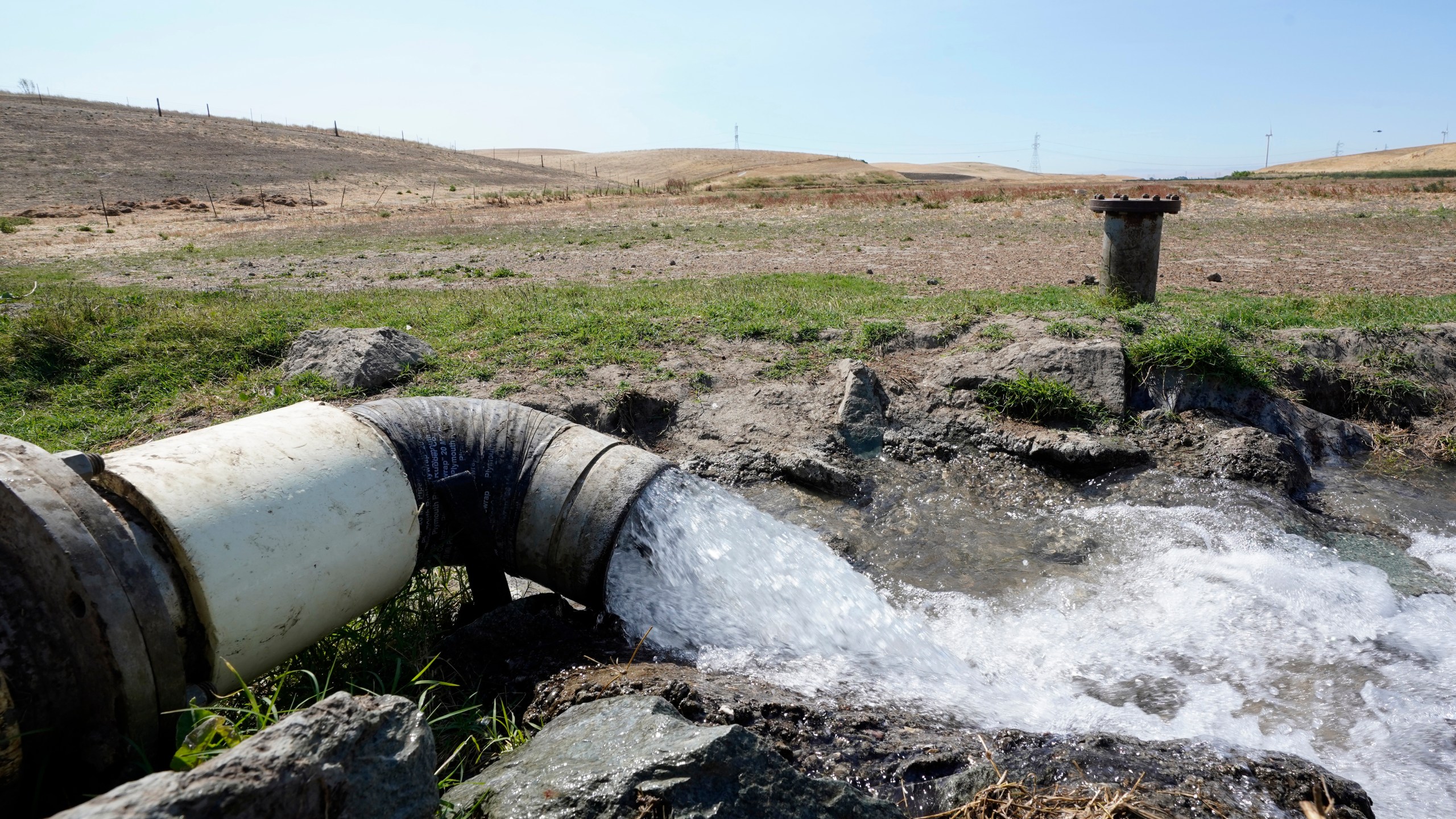 FILE - Well water flows from pumps into a canal that will be used to irrigate a vineyard, Monday, July 25, 2022, in Rio Vista, Calif. (AP Photo/Rich Pedroncelli, File)