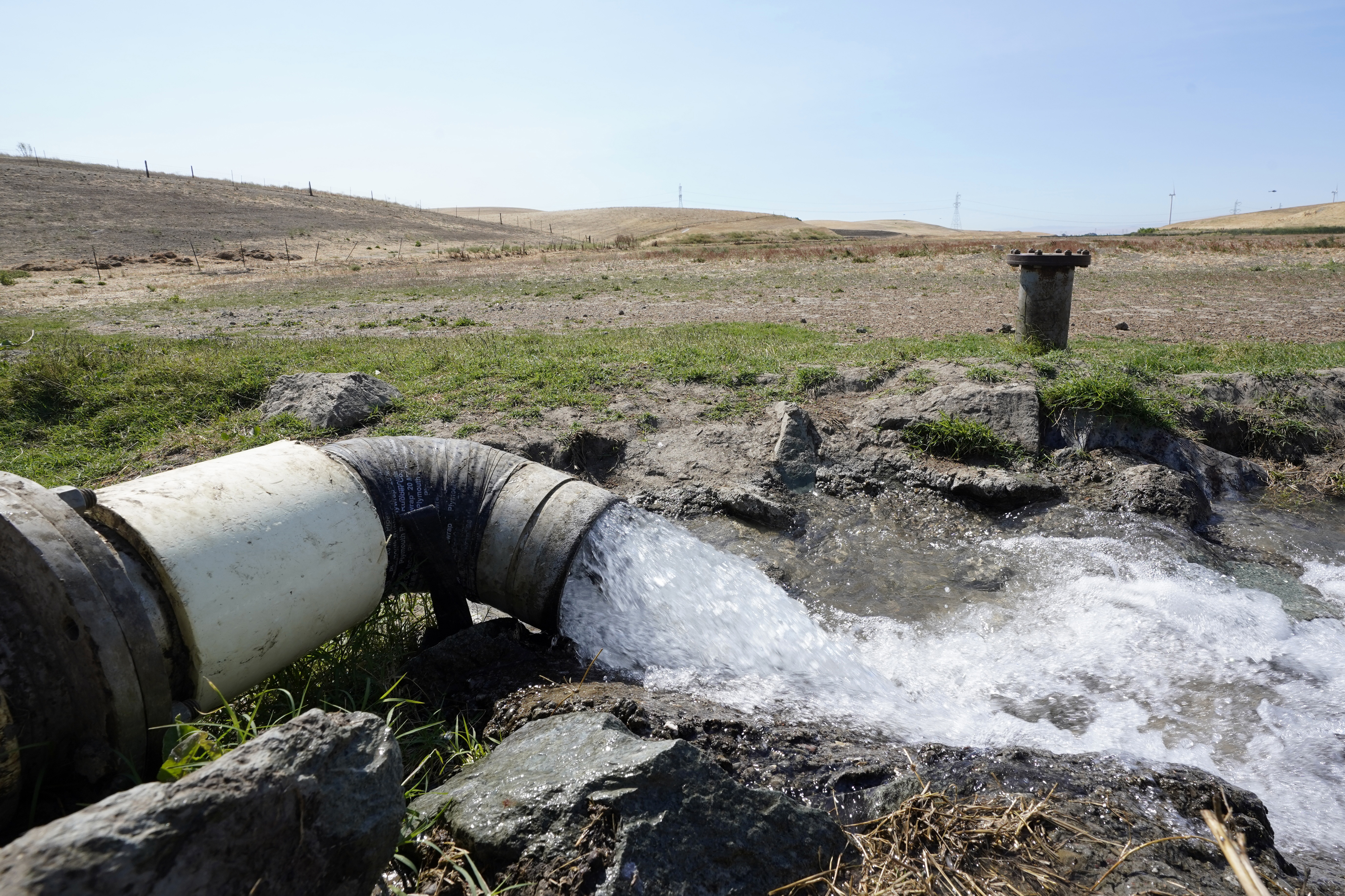 FILE - Well water flows from pumps into a canal that will be used to irrigate a vineyard, Monday, July 25, 2022, in Rio Vista, Calif. (AP Photo/Rich Pedroncelli, File)