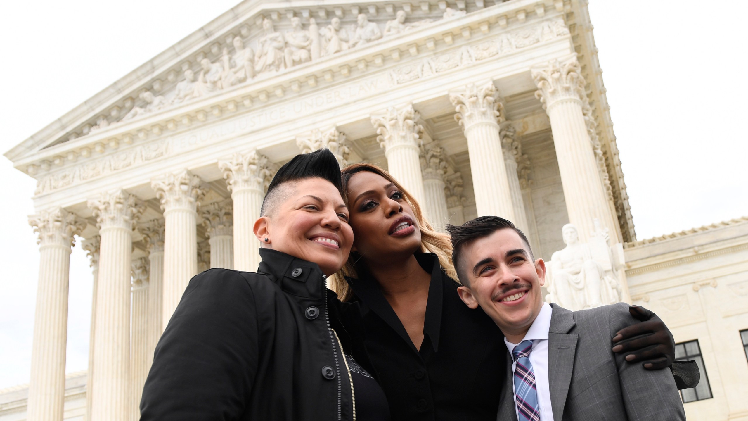 FILE - Sara Ramirez, from left, Laverne Cox and Chase Strangio, an attorney with the American Civil Liberties Union, pose for a photo outside the Supreme Court in Washington, Oct. 8, 2019. (AP Photo/Susan Walsh, File)