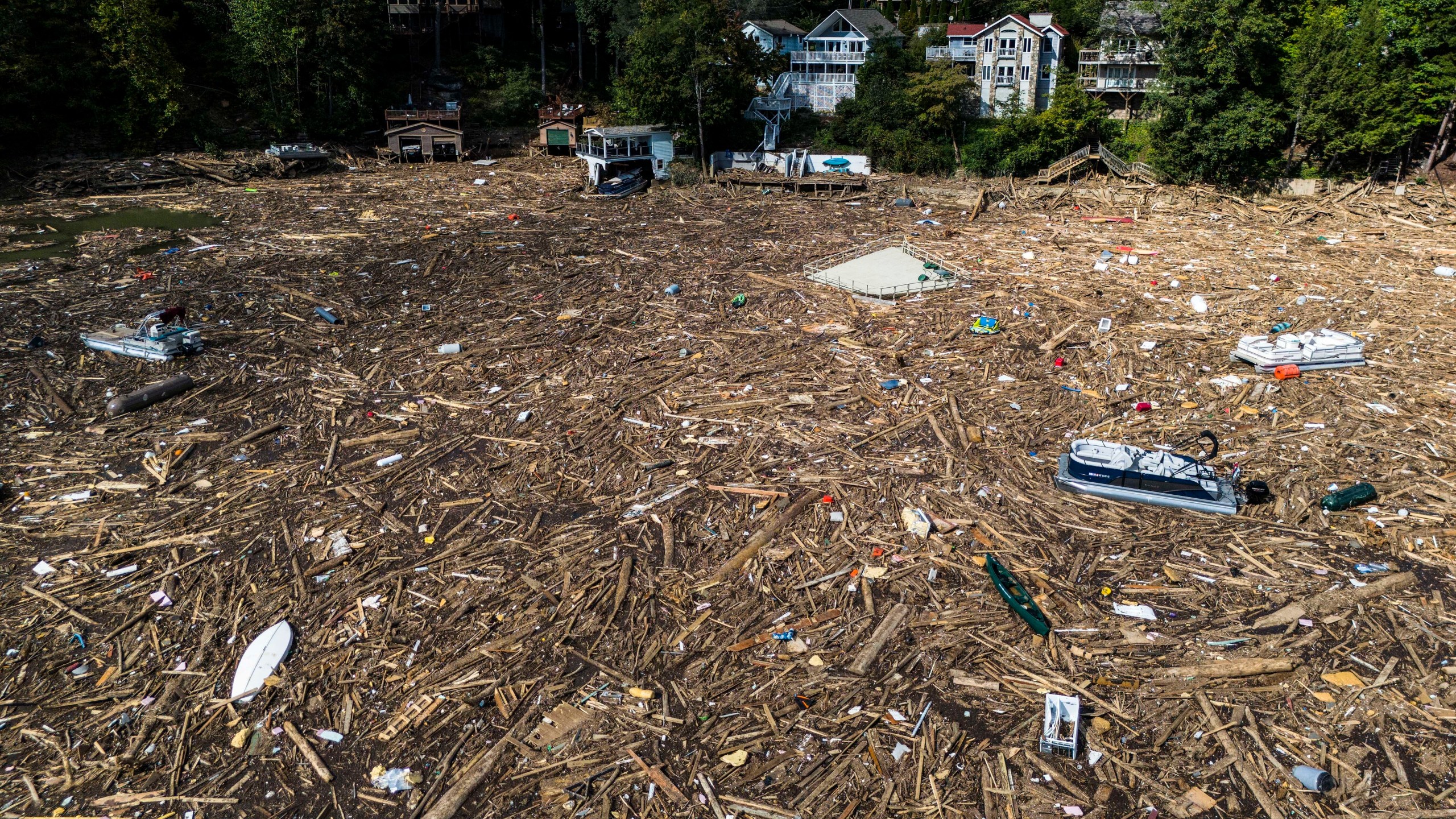 Debris is strewn on the lake in the aftermath of Hurricane Helene, Wednesday, Oct. 2, 2024, in Lake Lure, N.C. (AP Photo/Mike Stewart)