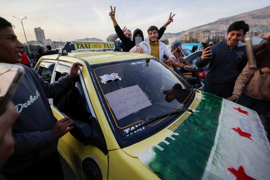 Syrian citizens celebrate during the third day of the take over of the city by the insurgents in Damascus, Syria, Tuesday, Dec. 10, 2024. (AP Photo/Omar Sanadiki)