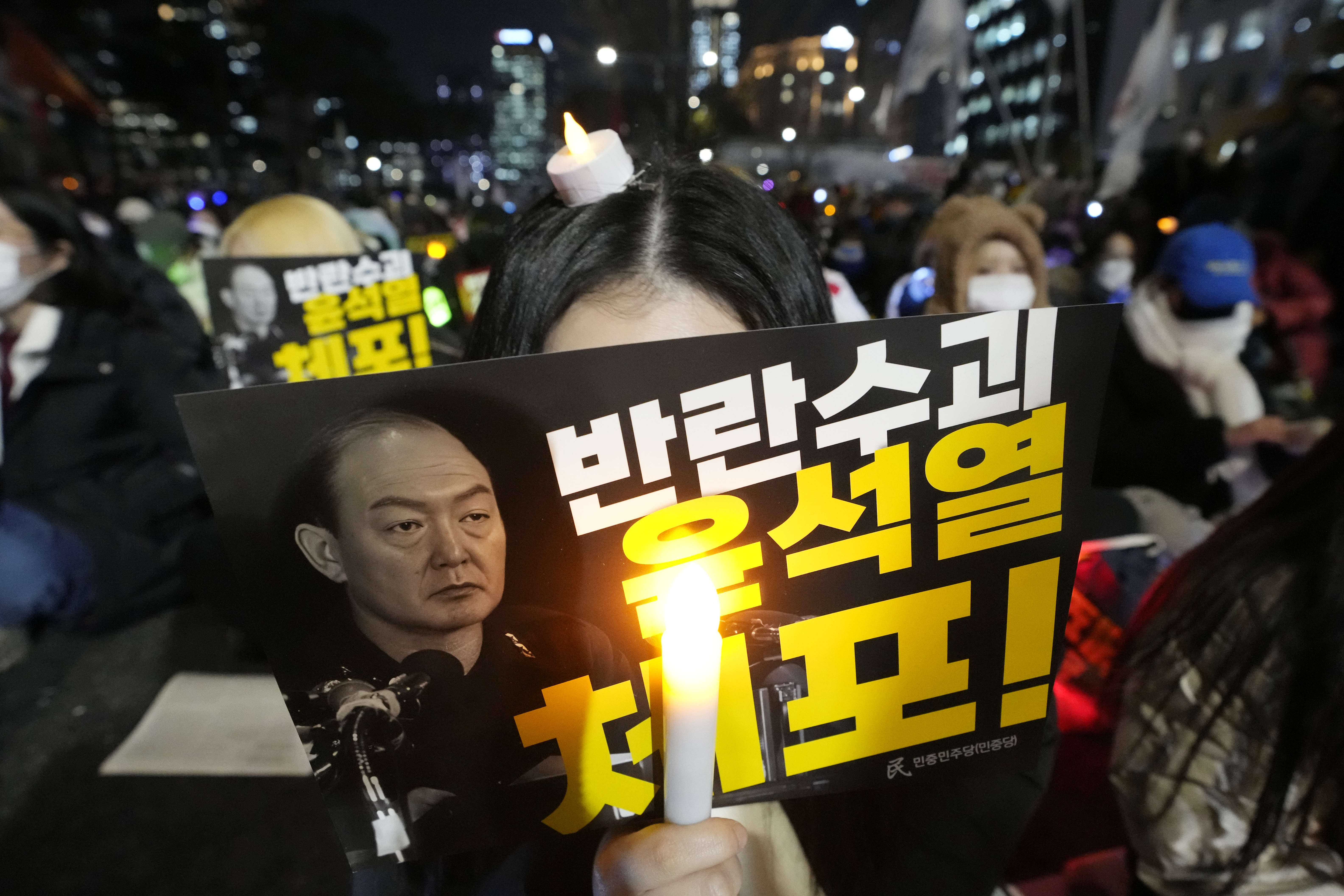 A participant holds a banner with writing reading "Arrest the rebellion leader Yoon Suk Yeol", during a rally to demand South Korean President Yoon Suk Yeol's impeachment outside the National Assembly in Seoul, South Korea, Wednesday, Dec. 11, 2024. (AP Photo/Ahn Young-joon)