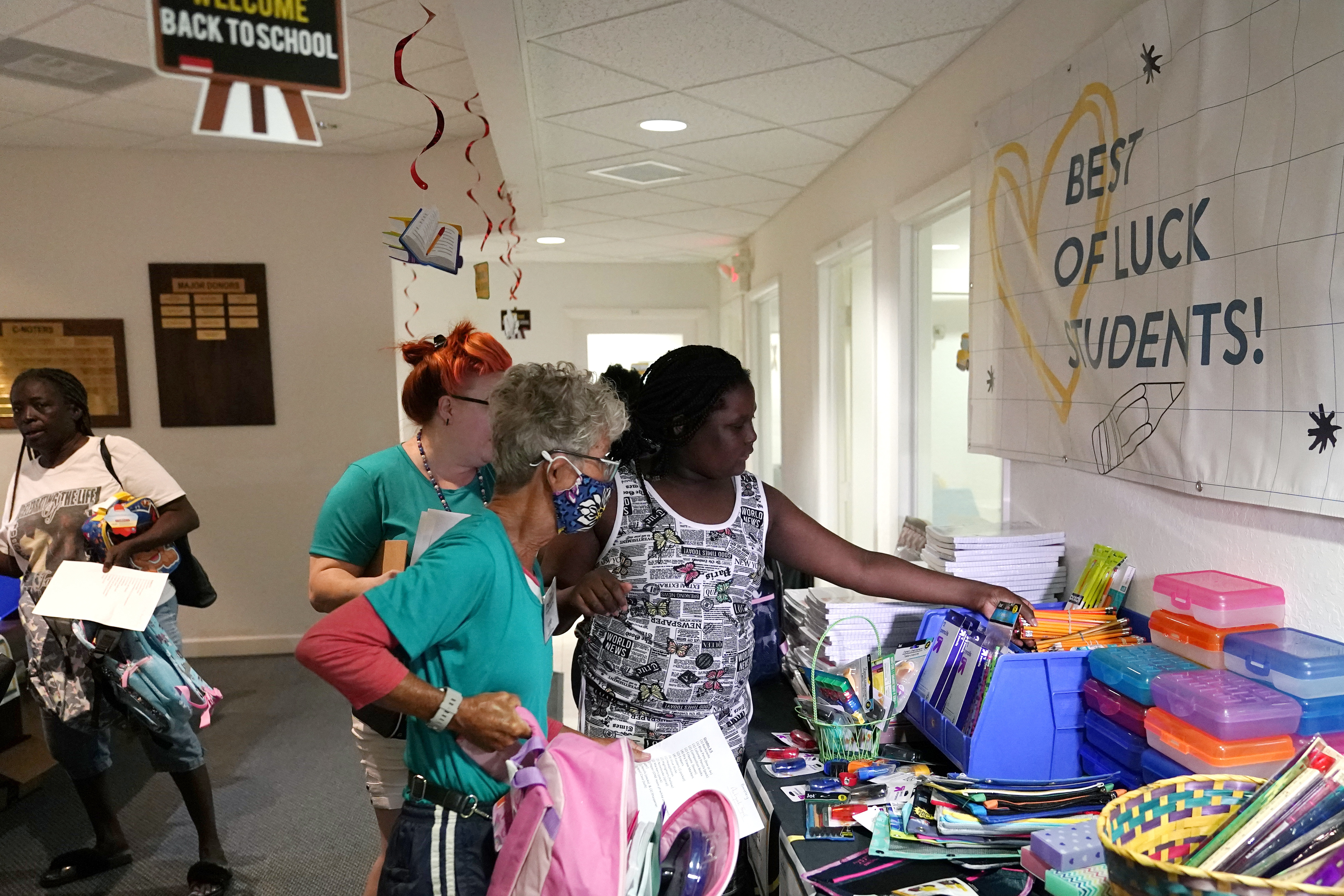 FILE - Aaliyah Floyd, 10, right, selects school supplies with volunteer Cindy Blomquist, left, at the annual Back to School Distribution Day at The Pantry, Friday, July 29, 2022, in Fort Lauderdale, Fla. The Pantry works with grandparents who are the primary caregivers for their grandchildren, offering free backpacks, lunch boxes, school supplies and sneakers. (AP Photo/Lynne Sladky, File)