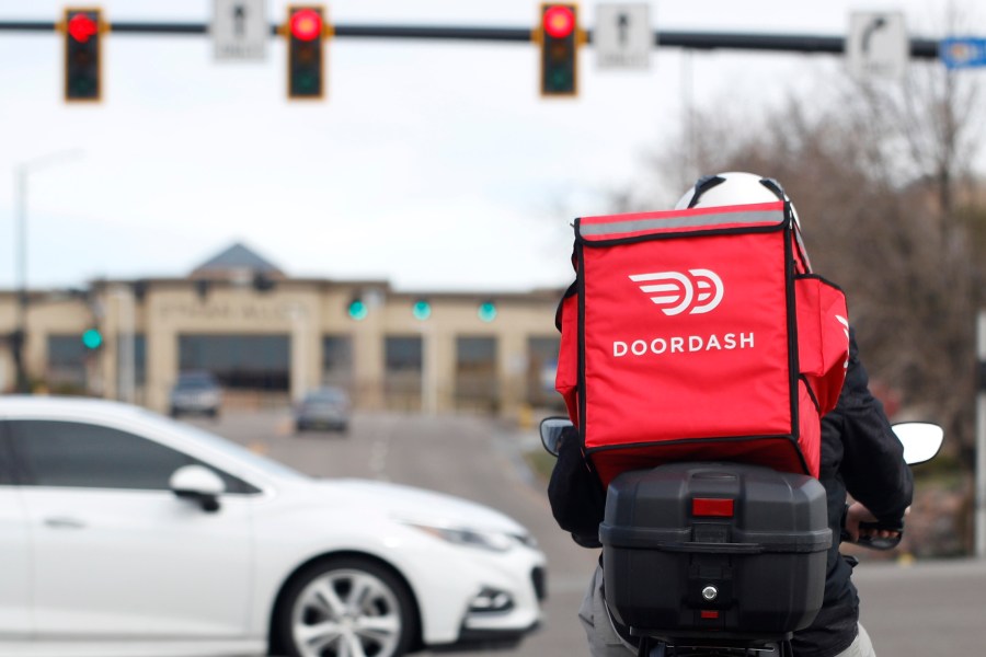 FILE - A food delivery rider waits for the traffic light to change Monday, March 30, 2020, in Lone Tree, Colo. (AP Photo/David Zalubowski, File)