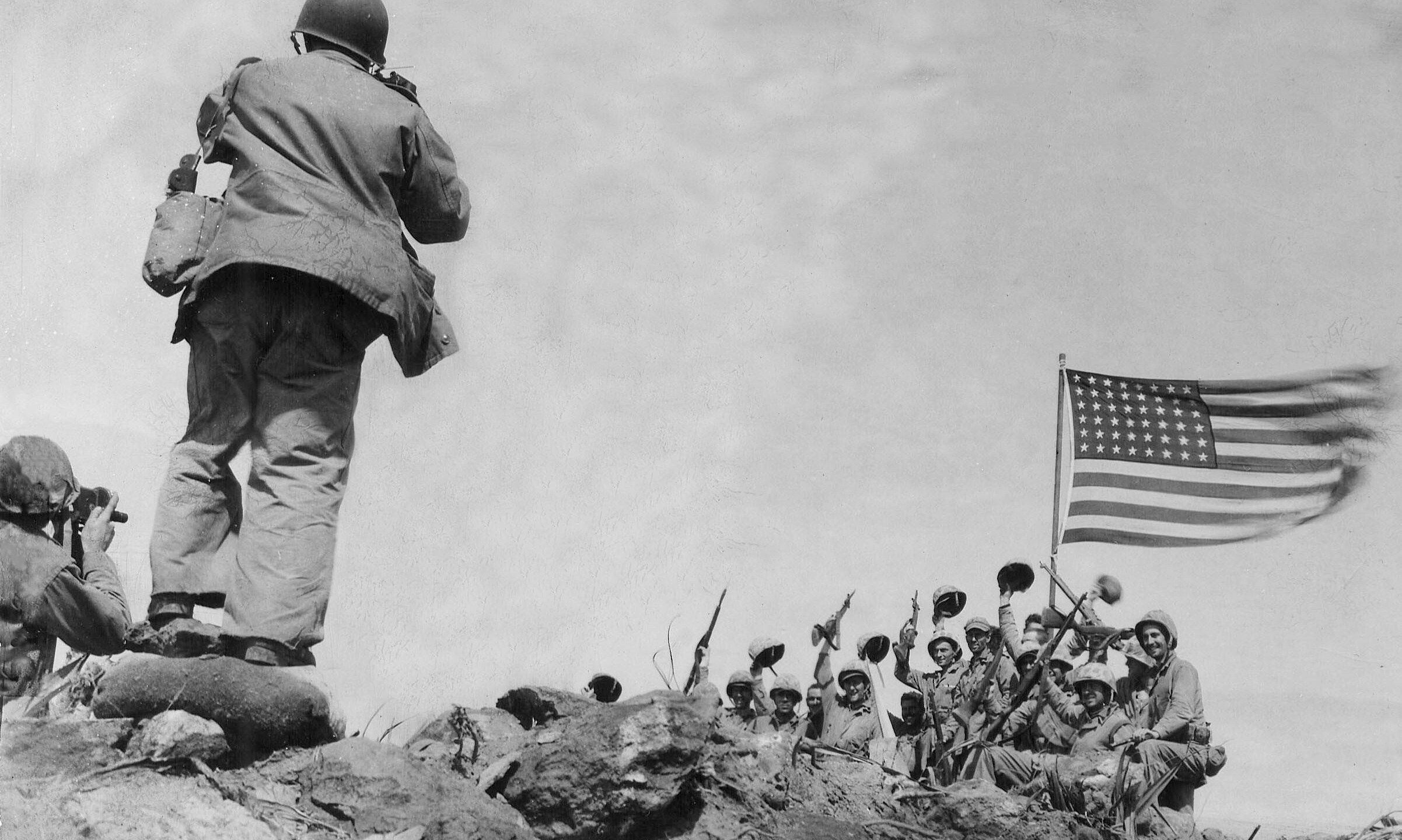 In this image provided by the U.S. Marine Corps, Marines of the 28th Regiment, 5th Division, AP photographer Joe Rosenthal photographs soldiers in front of the U.S. flag atop Mt. Suribachi, Iwo Jima, Japan, Feb. 23, 1945. (USMC/Pfc. Bob Campbell via AP)