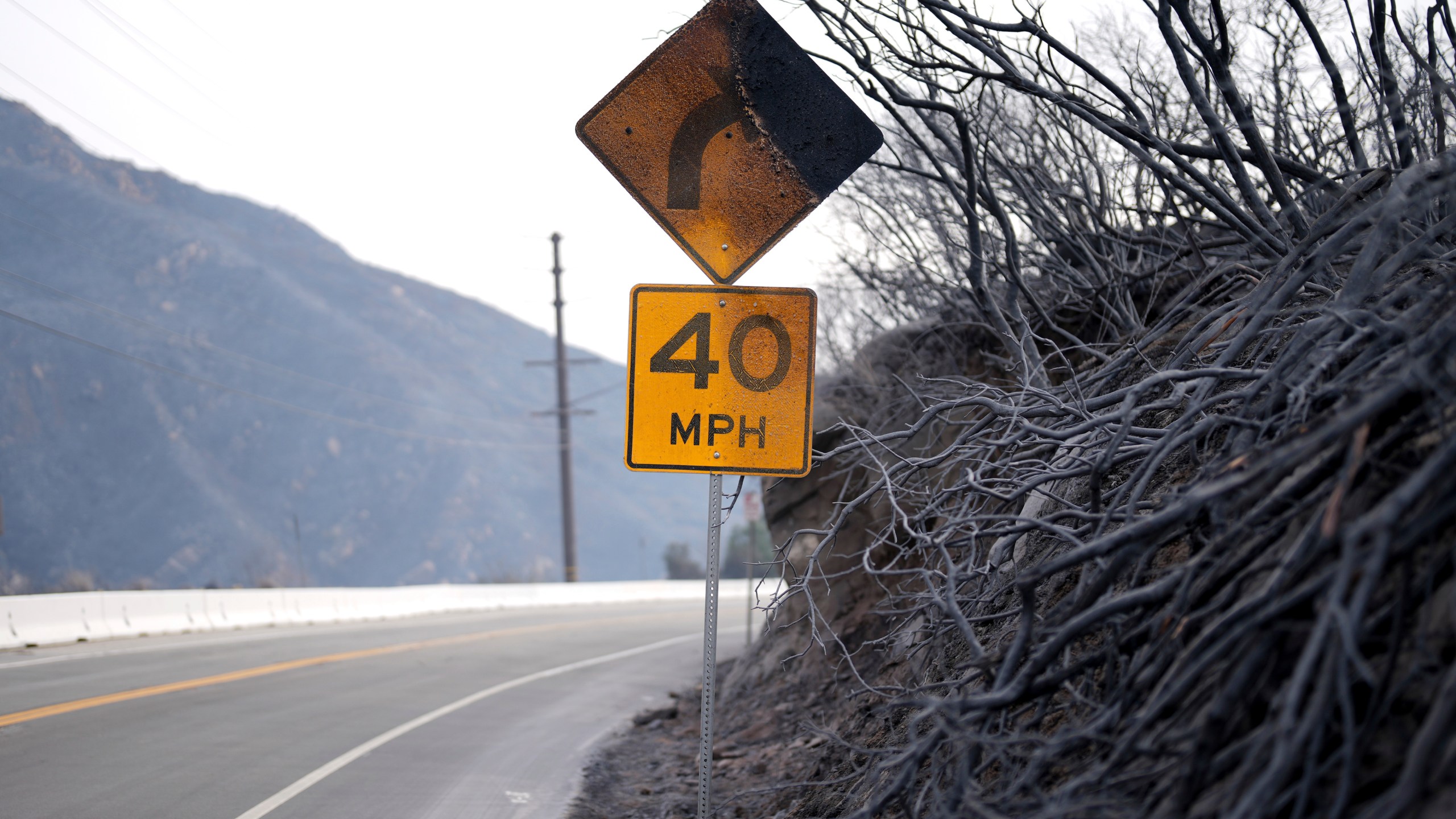 A road signed is burned after the Franklin Fire swept through Wednesday, Dec. 11, 2024, in Malibu, Calif. (AP Photo/Eric Thayer)