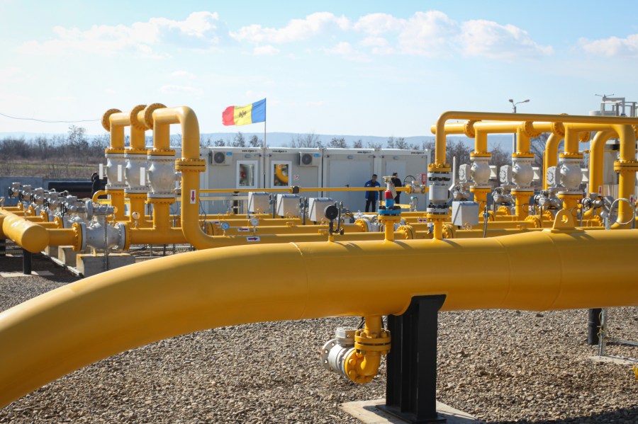 FILE - Men stand next to pipelines of the national natural gas distribution network outside Ungheni, Moldova, March 4, 2015. (AP Photo/Aurel Obreja)