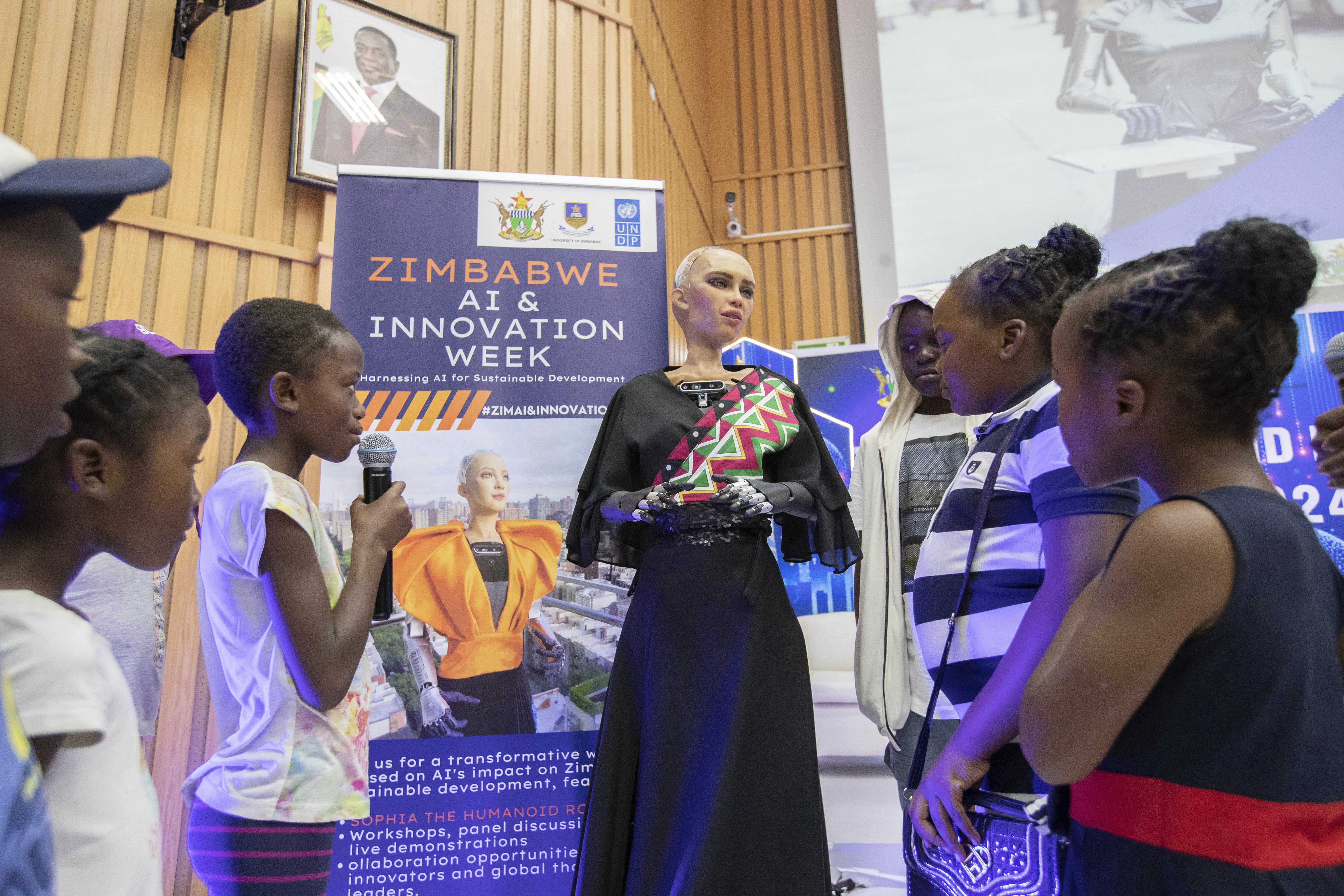 Sophia, the humanoid robot, responds to questions from children at the University of Zimbabwe, Harare, Friday, 13 Dec. 2024. (AP Photo/Aaron Ufumeli)