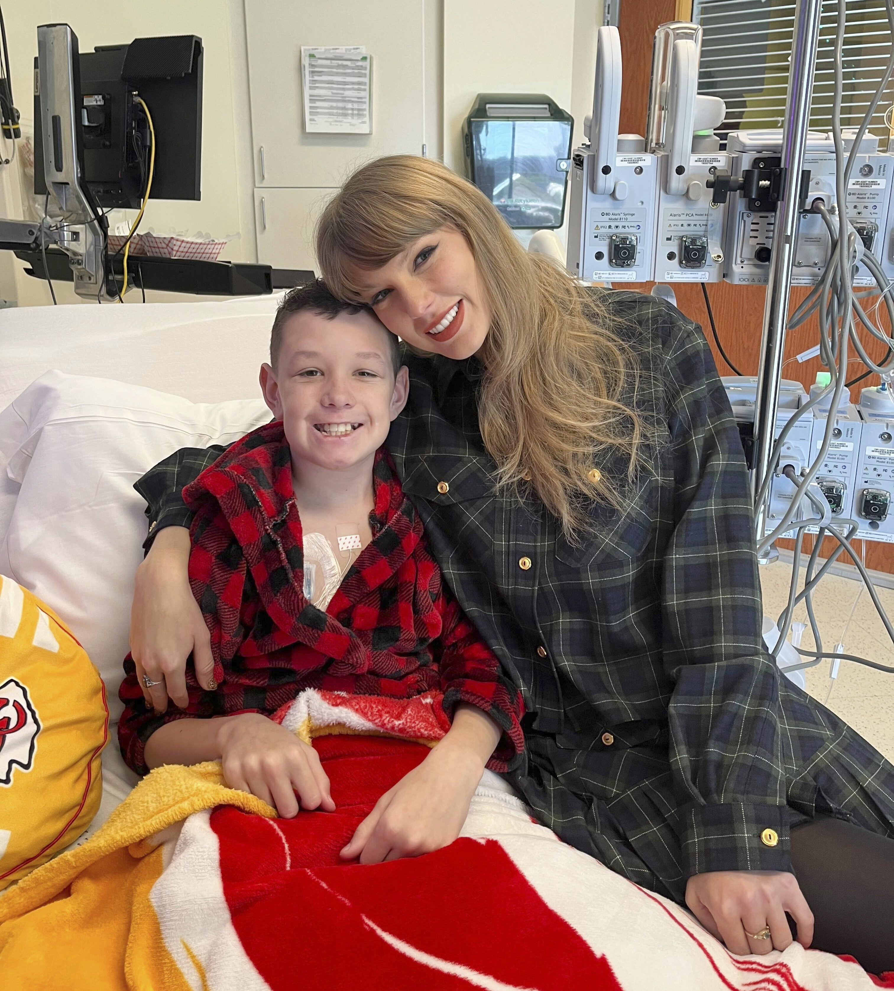 In this image provided by Cassie Thomas, Beckett Thomas, 13, who is a patient at Children's Mercy Hospital in Kansas City, Mo., poses with Taylor Swift, Thursday, Dec. 12, 2024. (Cassie Thomas via AP)