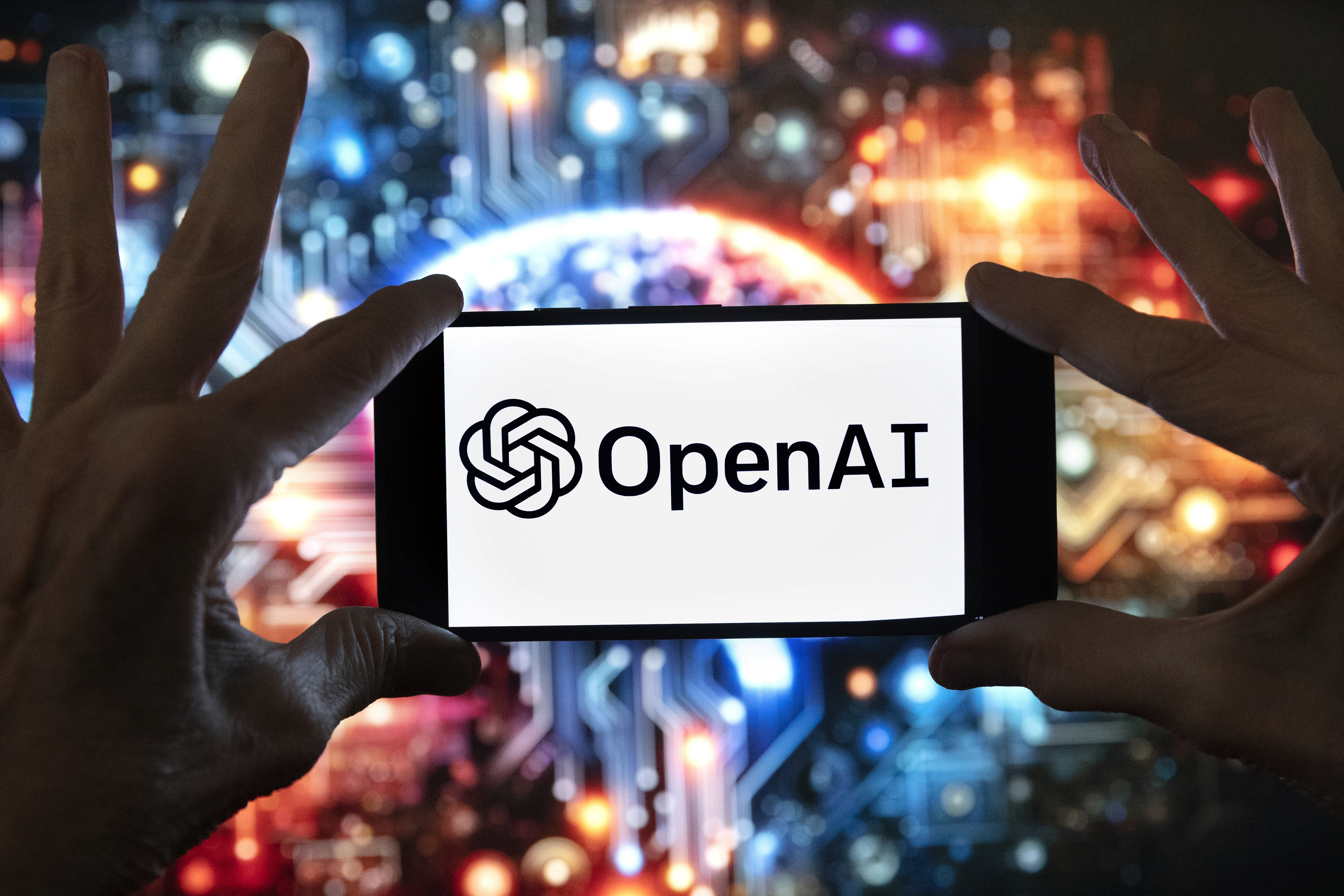 FILE - The OpenAI logo is displayed on a cell phone in front of an image generated by ChatGPT's Dall-E text-to-image model, Dec. 8, 2023, in Boston. (AP Photo/Michael Dwyer, File)