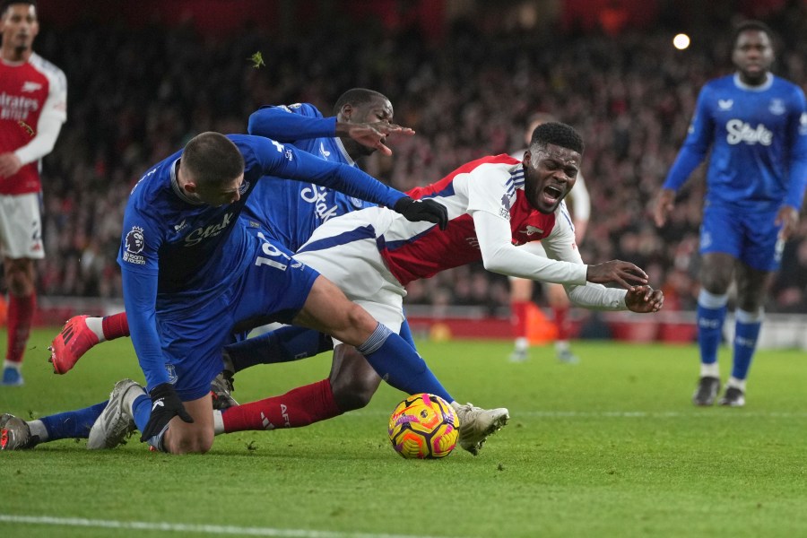 Arsenal's Thomas Partey, centre, challenges for the ball with Everton's Vitaliy Mykolenko during the English Premier League soccer match between Arsenal and Everton at Emirates Stadium in London, Saturday, Dec. 14, 2024. (AP Photo/Kin Cheung)