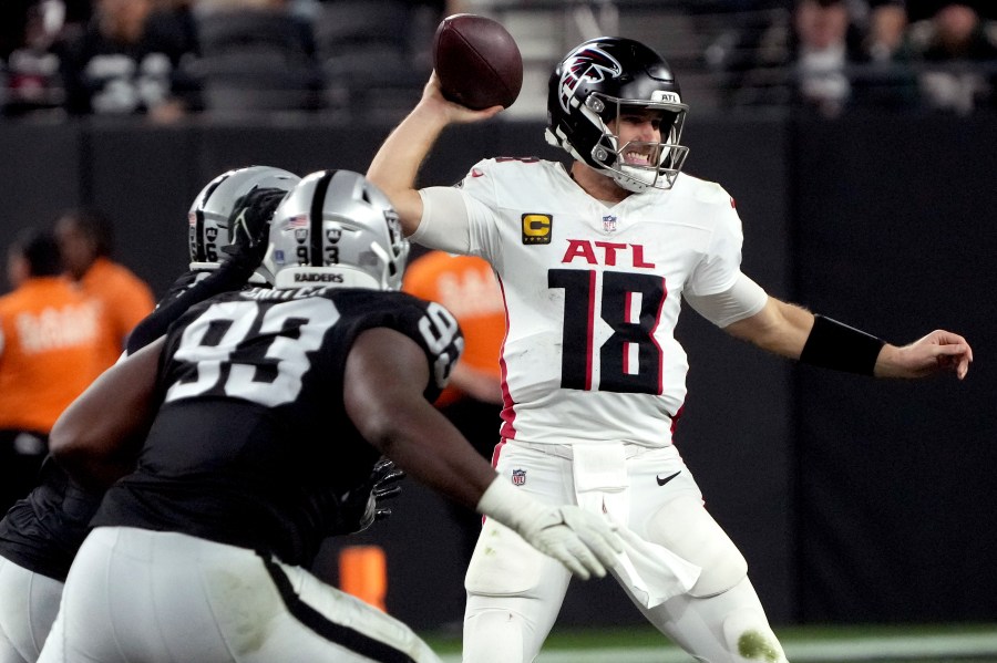 Atlanta Falcons quarterback Kirk Cousins (18) looks to throw as Las Vegas Raiders defensive tackle Zach Carter (93) pursues during the second half of an NFL football game, Monday, Dec. 16, 2024, in Las Vegas. (AP Photo/Rick Scuteri)