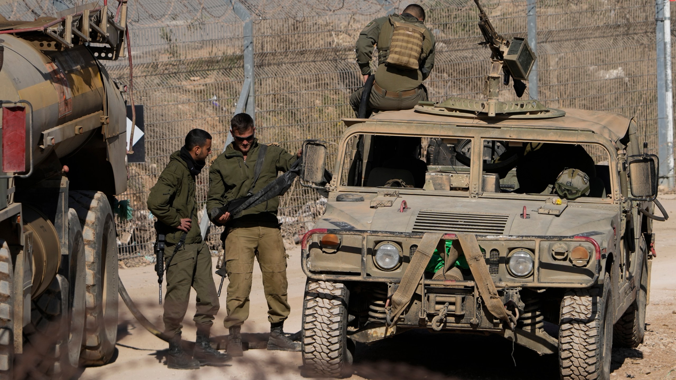 Israeli soldiers stand next to armoured vehicles after crossing the security fence, near the so-called Alpha Line that separates the Israeli-controlled Golan Heights from Syria, in the town of Majdal Shams, Tuesday, Dec. 17, 2024. (AP Photo/Matias Delacroix)