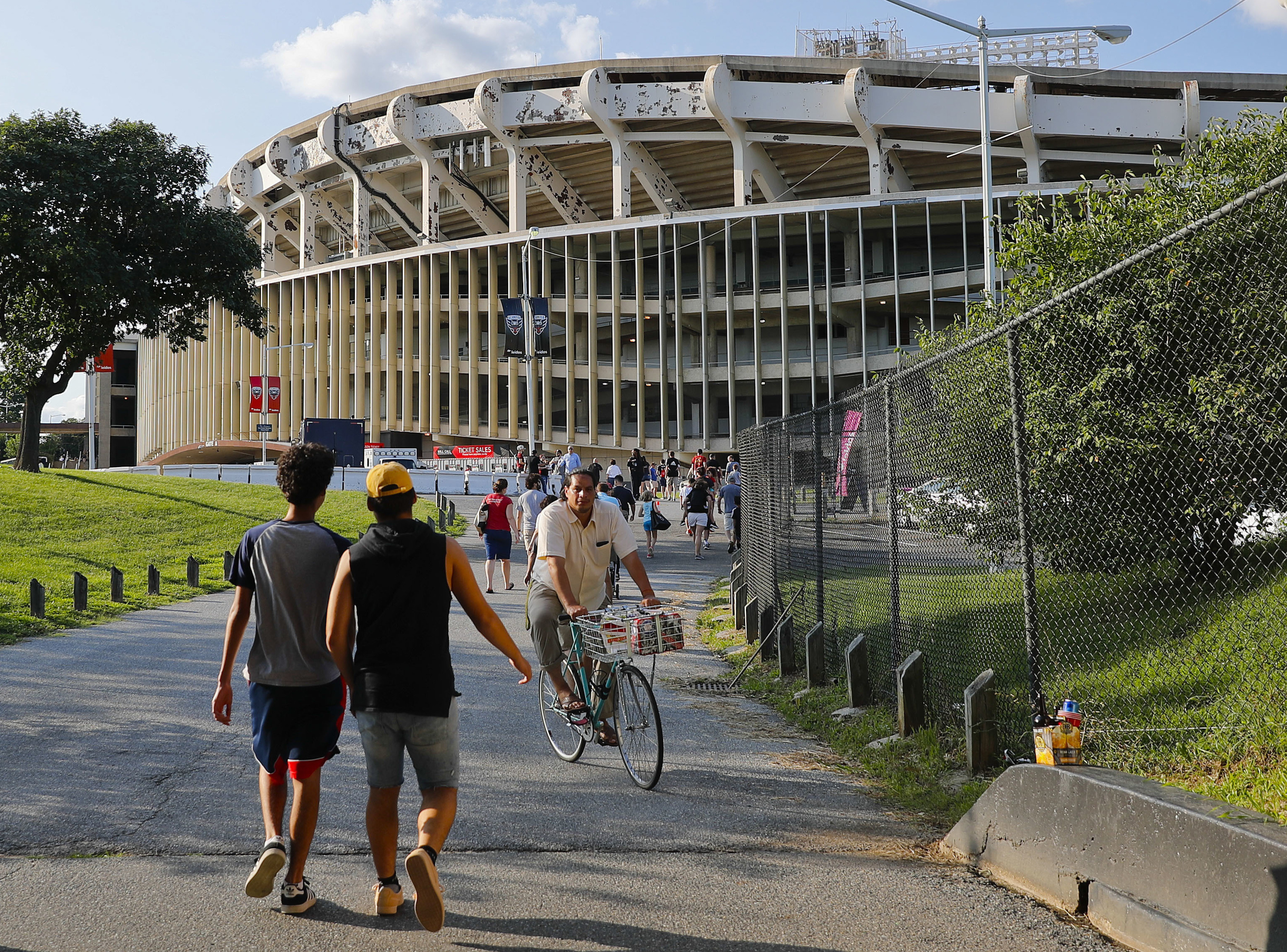 FILE - In this Aug. 5, 2017, file photo people make their way to RFK Stadium in Washington before an MLS soccer match between D.C. United and Toronto FC. (AP Photo/Pablo Martinez Monsivais, File)