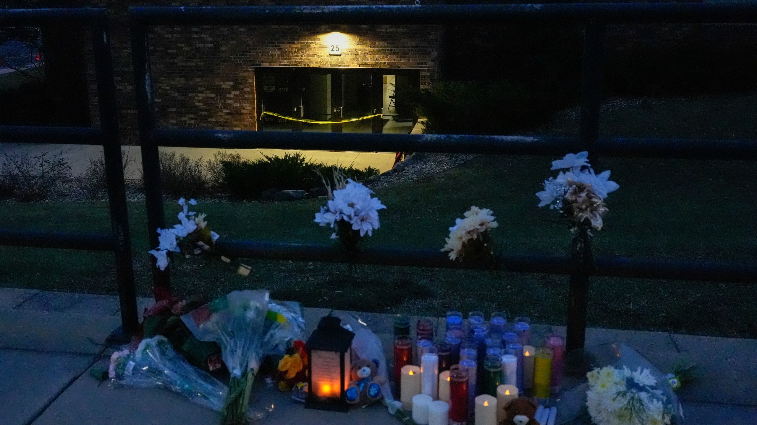 Flowers and candles are placed outside the Abundant Life Christian School Tuesday, Dec. 17, 2024 in Madison, Wis., following a shooting on Monday. (AP Photo/Nam Y. Huh)