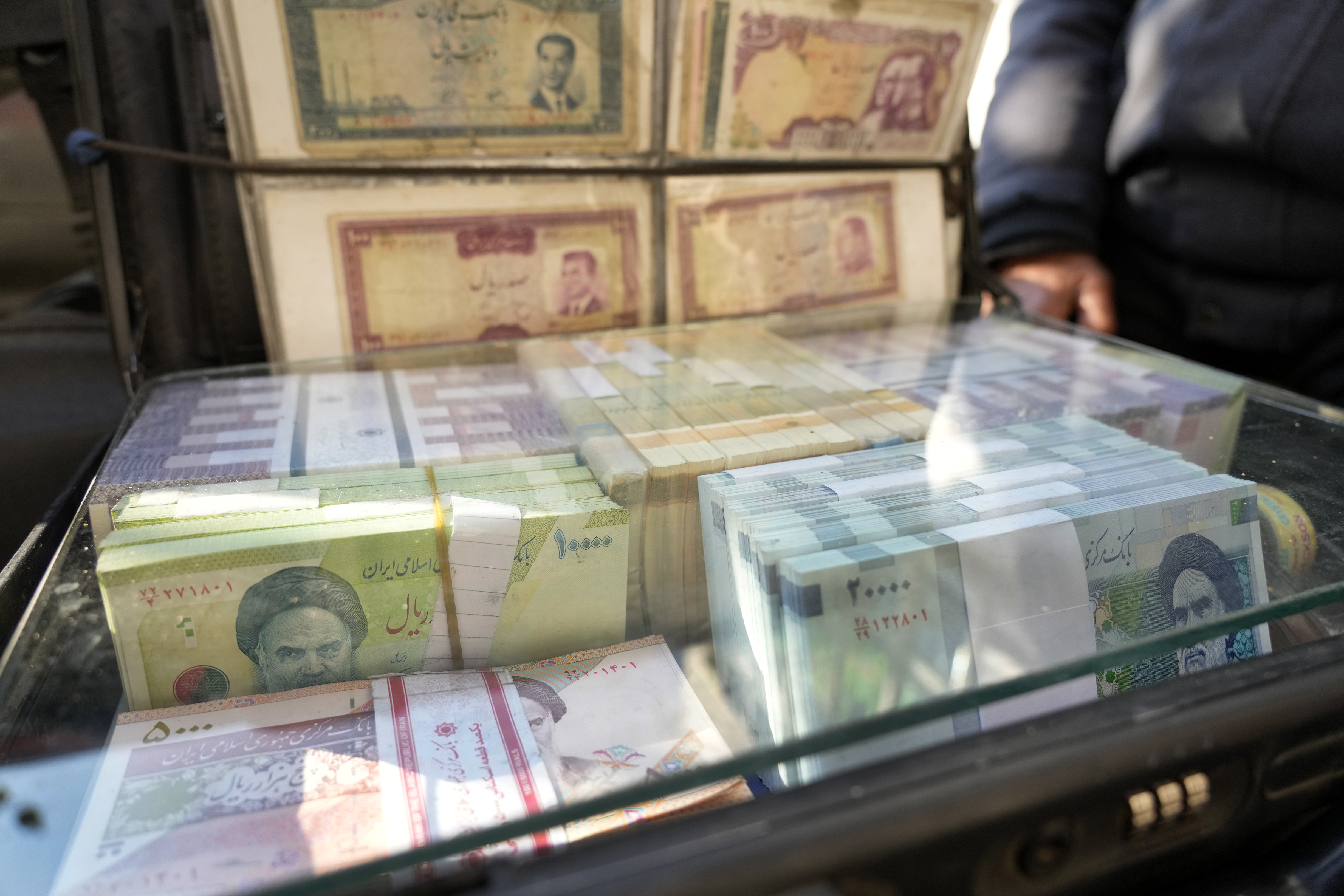 Current and pre-revolution Iranian banknotes are displayed by a street money exchanger at Ferdowsi St. in downtown Tehran, Iran, Sunday, Dec. 15, 2024. (AP Photo/Vahid Salemi)