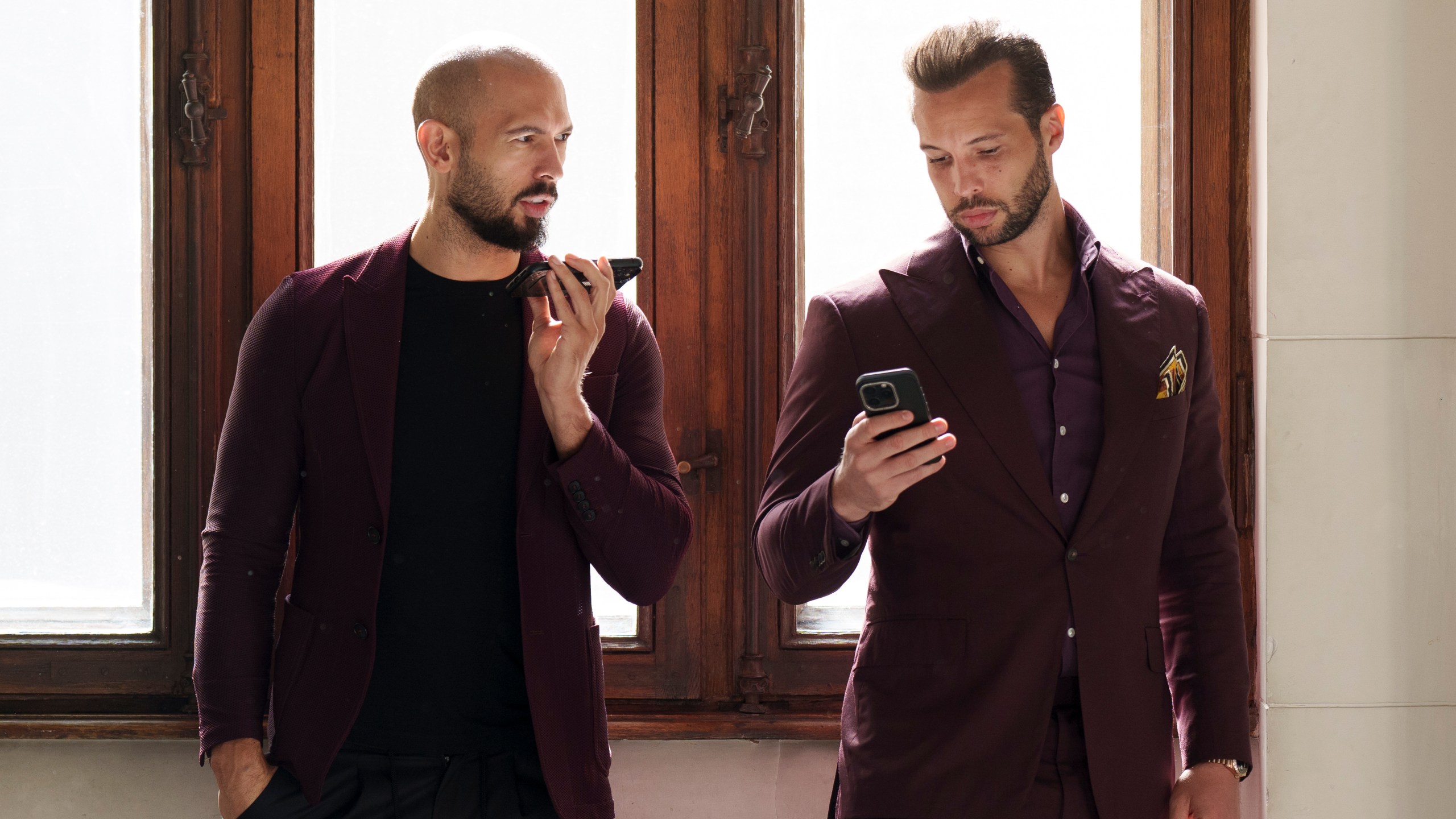 FILE - Andrew Tate, left, and his brother Tristan, right, wait at the Court of Appeals building in Bucharest, Romania, on Oct. 15, 2024. (AP Photo/Vadim Ghirda, File)