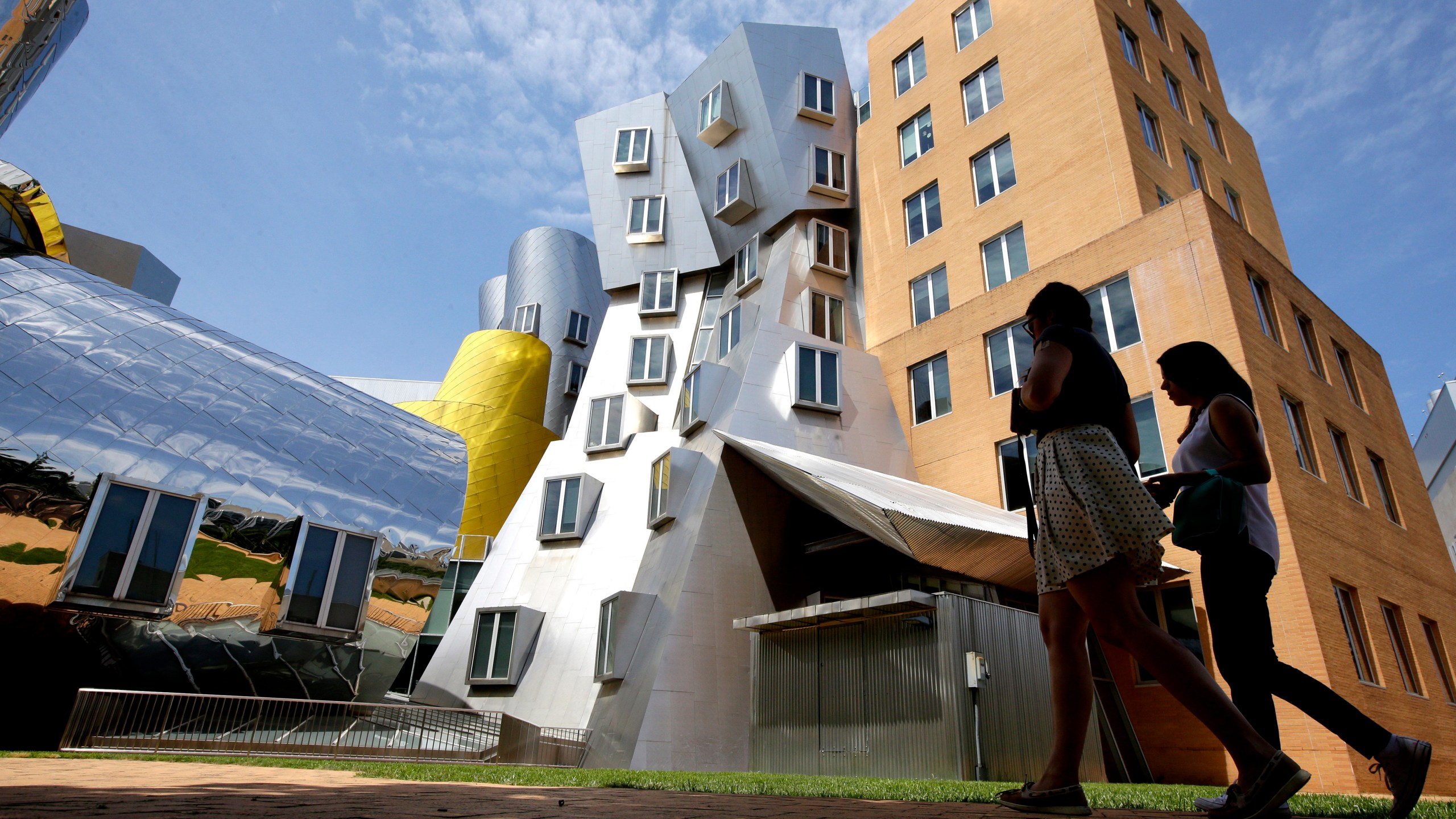 FILE - People walk past the Ray and Maria Stata Center on the campus of the Massachusetts Institute of Technology, in Cambridge, Mass., on July 16, 2019. (AP Photo/Steven Senne, File)