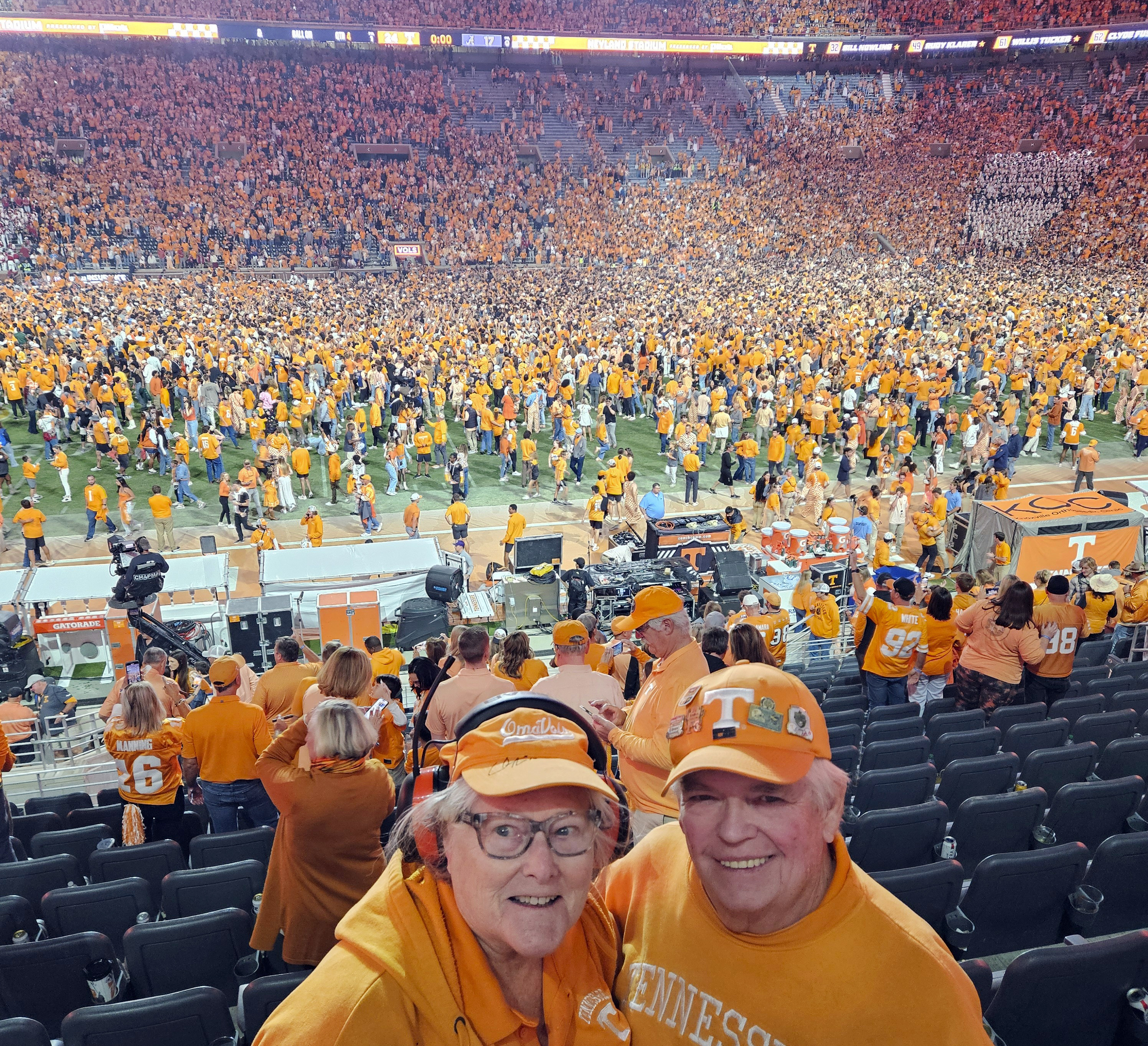 In this image provided by Earl Brown, Brown and his wife Judy pose as Tennessee fans storm the field after the Volunteers defeated Alabama in an NCAA college football game, Saturday, Oct. 19, 2024, in Knoxville, Tenn. (Earl Brown via AP)