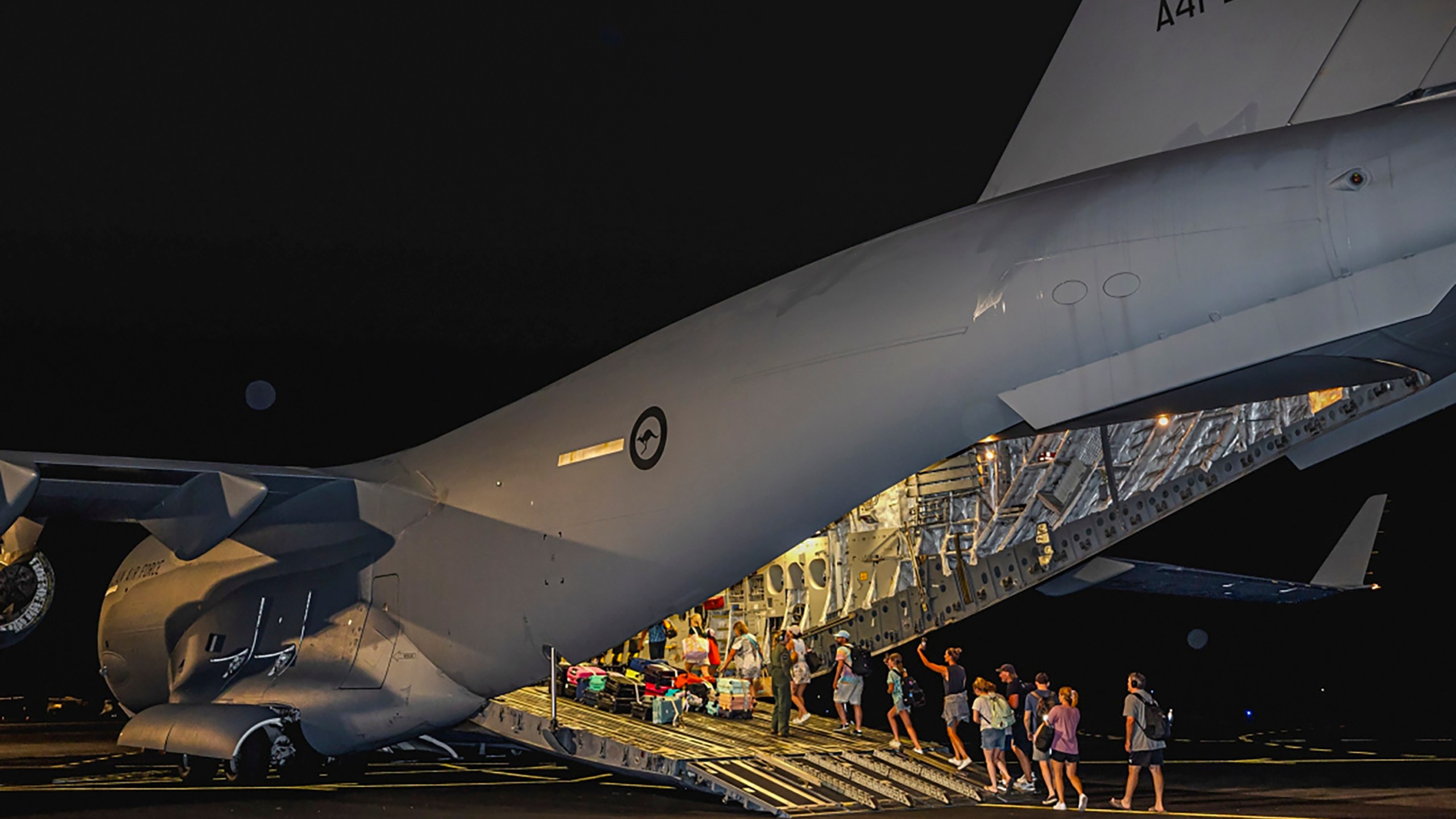 In this photo released by Australian Department of Defence, Australian citizens board a Royal Australian Air Force aircraft for a flight home from Bauerfield International Airport, Port Vila, Vanuatu, Wednesday, Dec. 18, 2024 following a powerful earthquake that struck just off the coast of Vanuatu in the South Pacific Ocean. (CPL Adam Abela/Australian Department of Defence via AP)