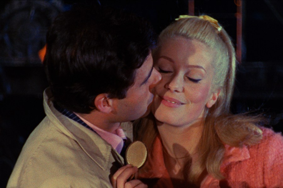 This image released by Janus Films shows Nino Castelnuovo, left, and Catherine Deneuve in a scene from the 1964 French film "The Umbrellas of Cherbourg." (Janus Films via AP)