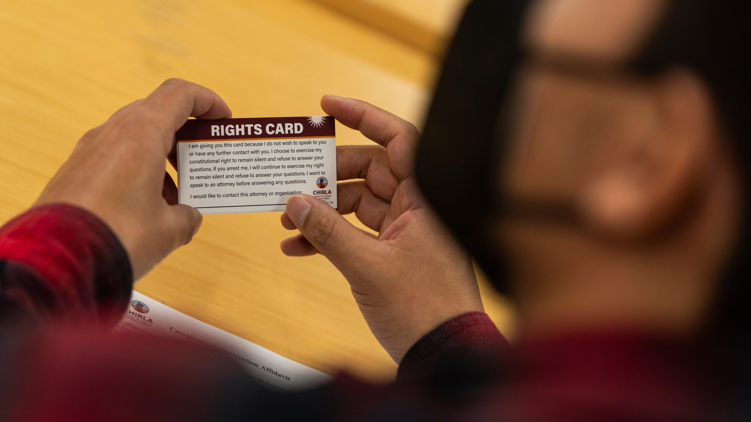 A participant holds a "rights card" during a bilingual workshop for immigrants who want to stay in the United States at the office of the Coalition for Humane Immigrant Rights organization in Los Angeles, Wednesday, Dec. 4, 2024. (AP Photo/Jae C. Hong)