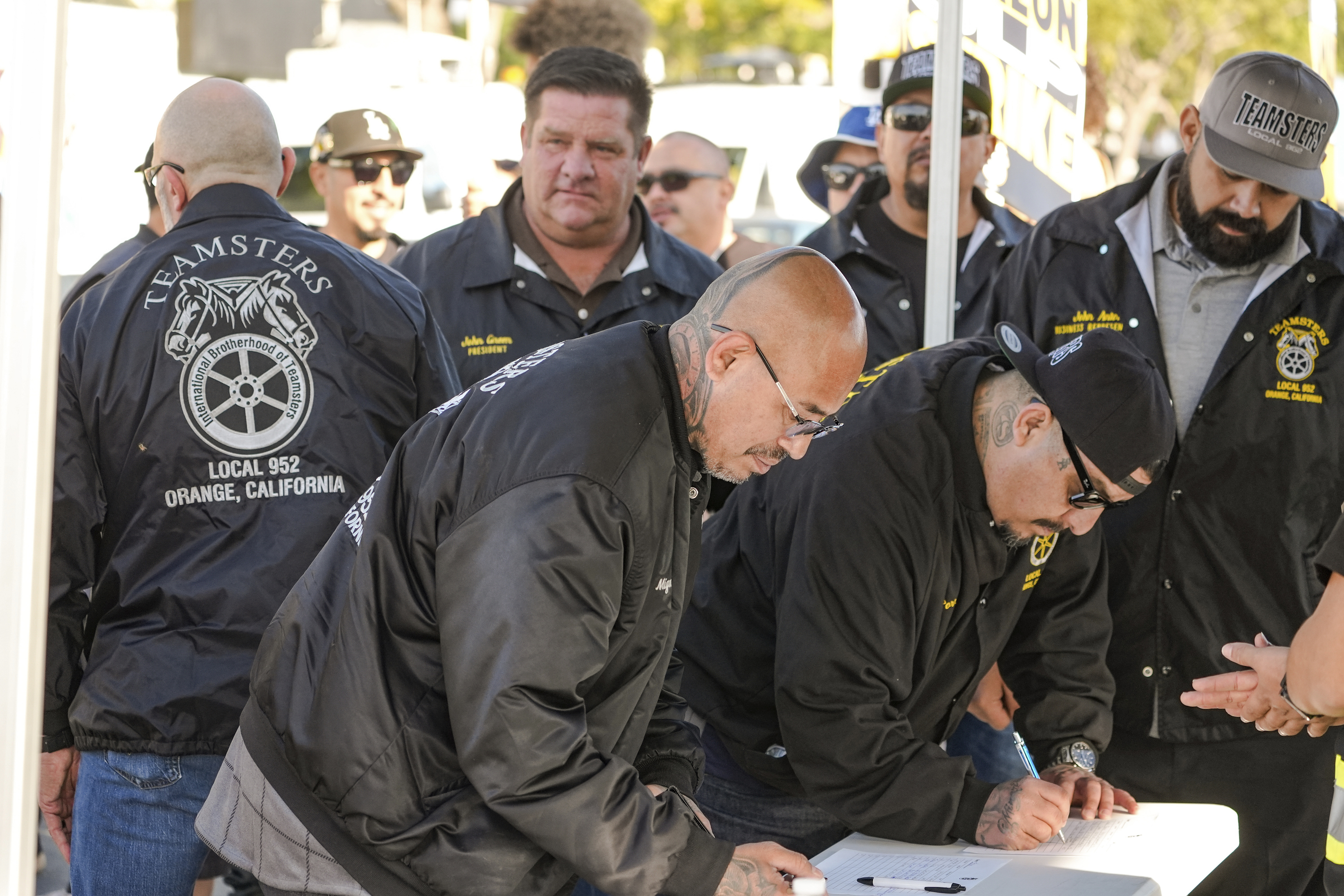 Teamsters Local 952 members sign-in as they join Amazon workers striking outside the gates of an Amazon Fulfillment Center, Thursday, Dec. 19, 2024, in City of Industry, Calif. (AP Photo/Damian Dovarganes)