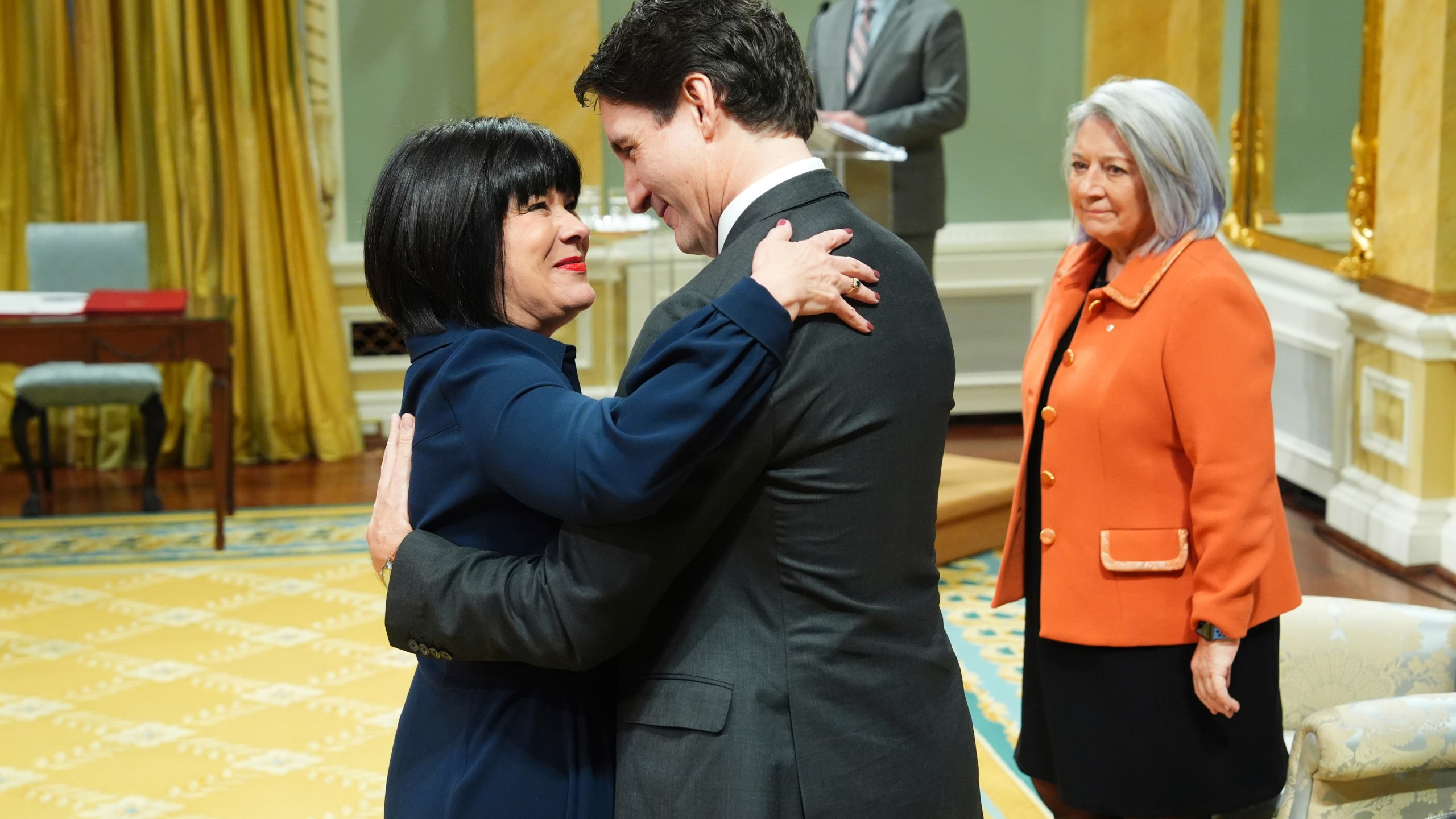 Treasury Board President Ginette Petitpas Taylor hugs Prime Minister Justin Trudeau as Gov. Gen. Mary Simon looks on during a cabinet swearing-in ceremony at Rideau Hall in Ottawa, on Friday, Dec.20, 2024.(Sean Kilpatrick /The Canadian Press via AP)