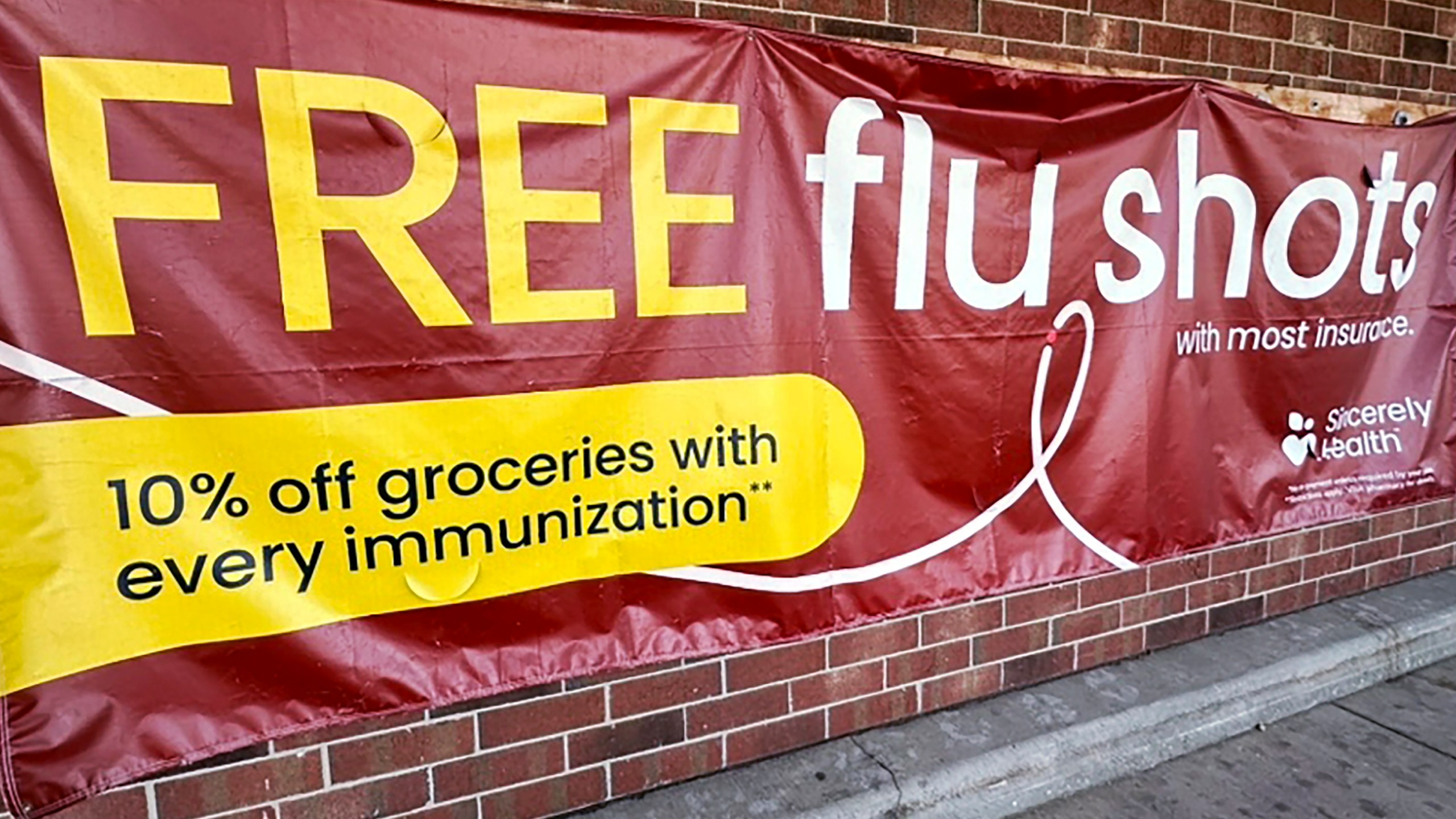 FILE - A sign for flu vaccination is displayed outside of a grocery store in Glenview, Ill., Thursday, Feb. 15, 2024. (AP Photo/Nam Y. Huh, File)