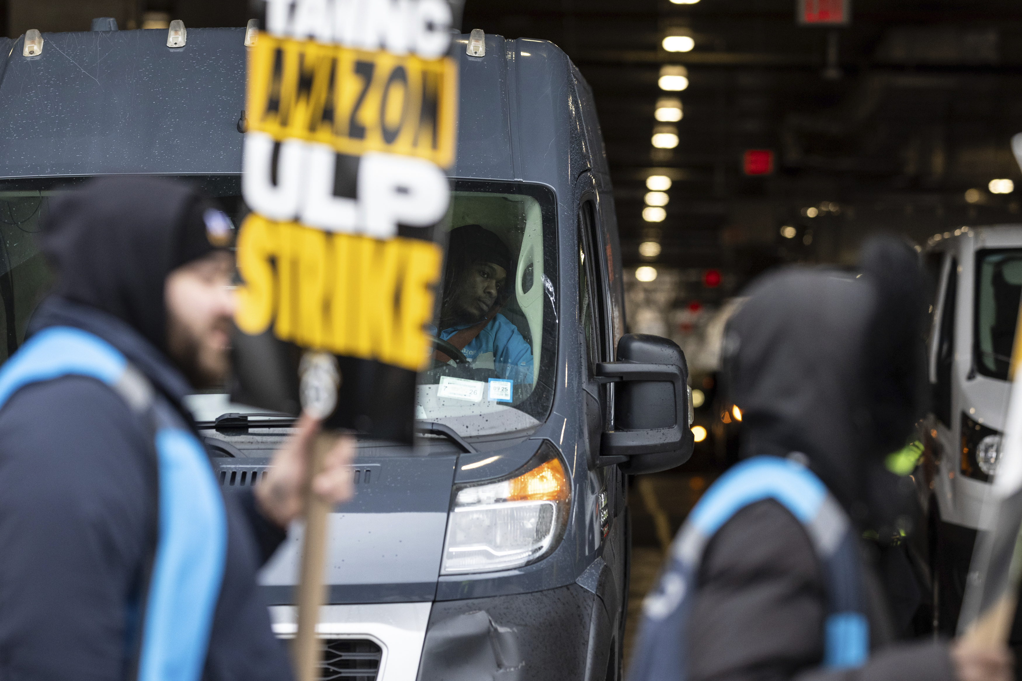 Amazon workers and members of the International Brotherhood of Teamsters picket in front of the Amazon fulfilment center in the Queens borough of in New York, on Friday, Dec. 20, 2024. (AP Photo/Stefan Jeremiah)